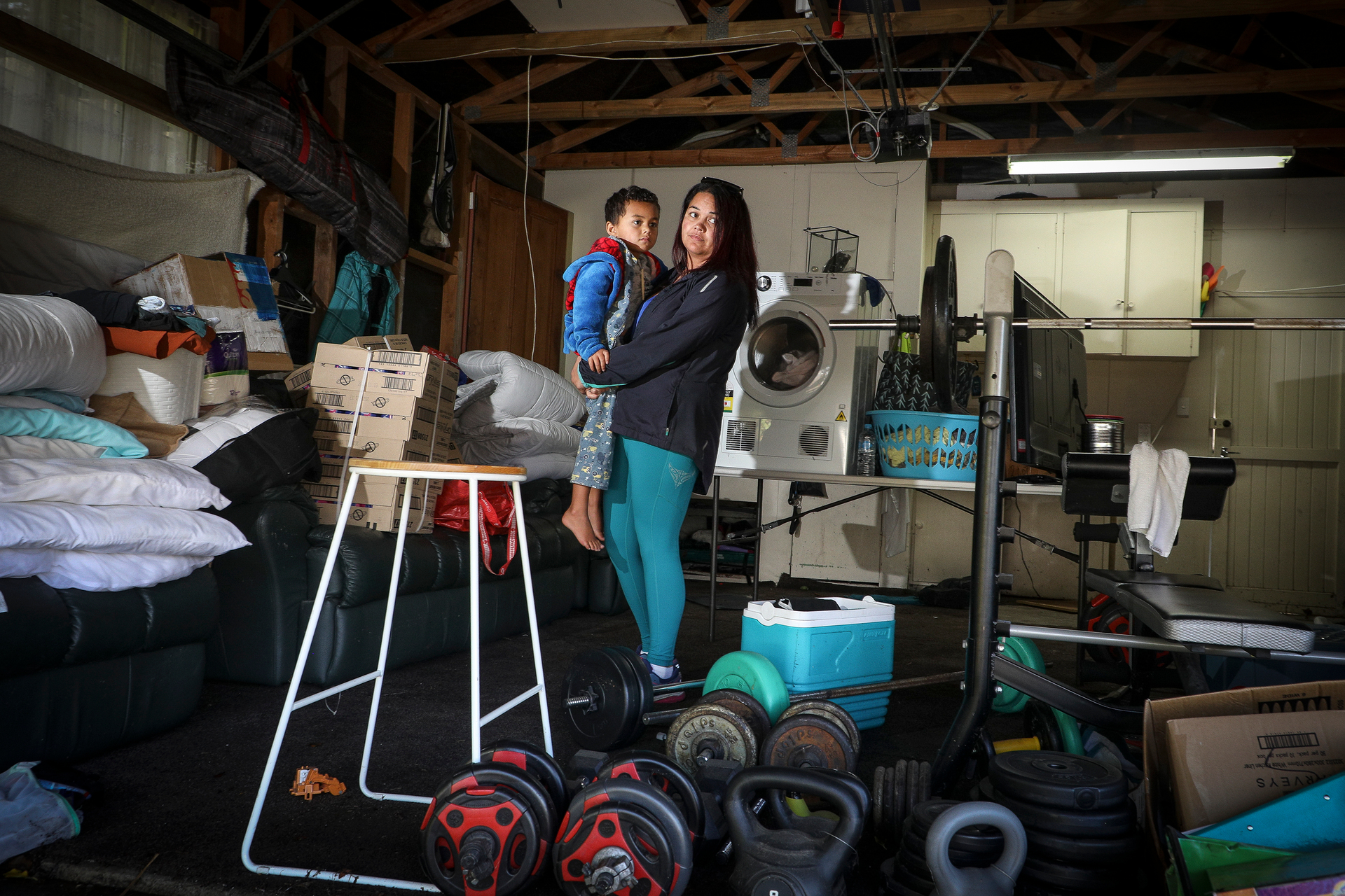 Mandy Rangiwhetu with her son Boston inside her garage after it was flooded in 2021. Photo / NZME 