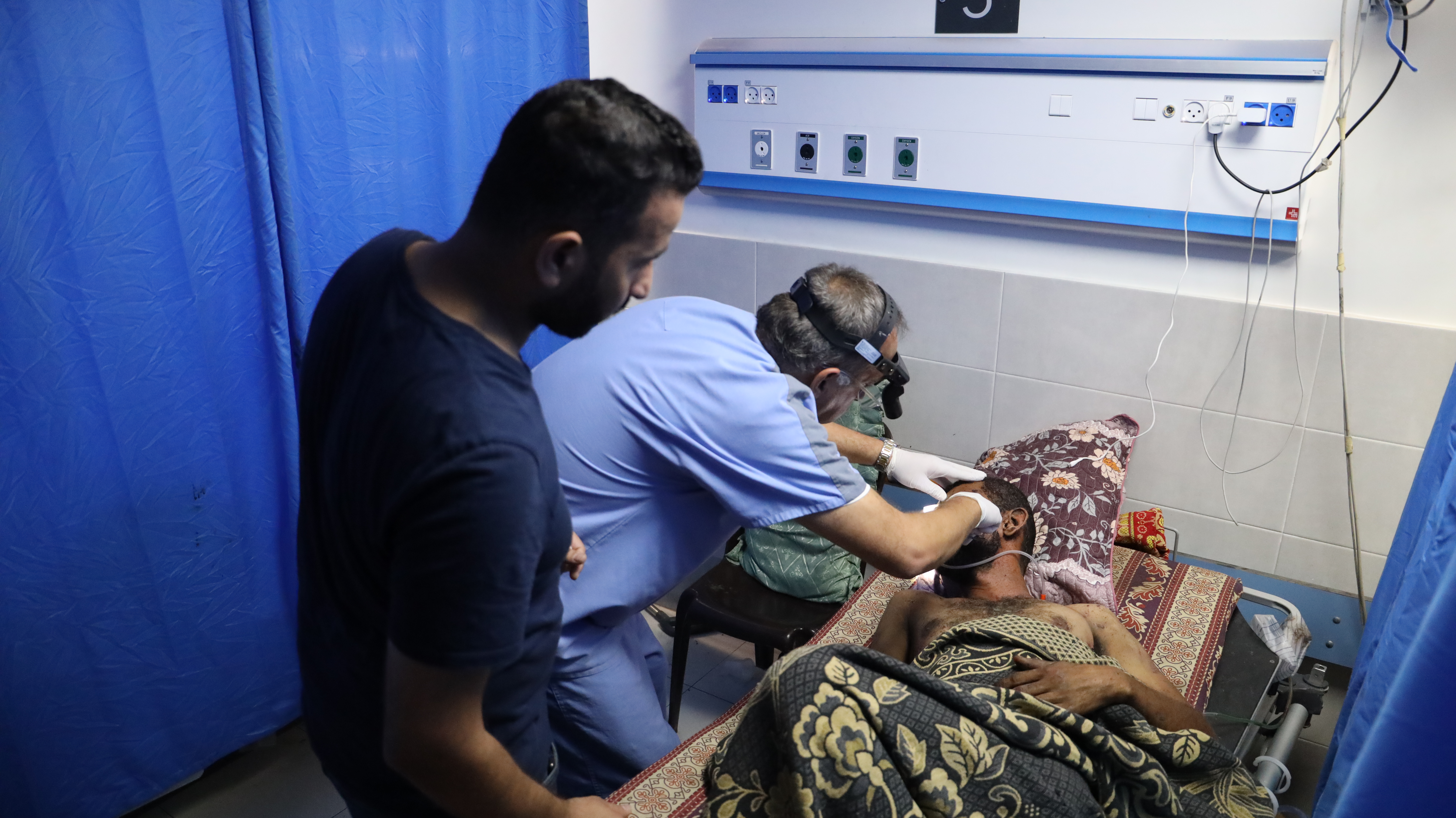 MSF personnel treat a patient with a facial injury at Al-Shifa hospital. Photo / MSF