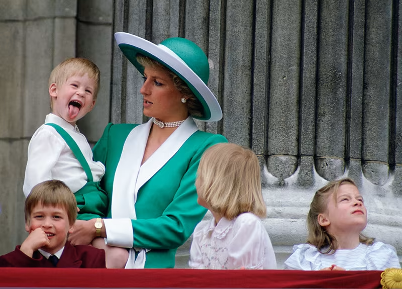 Prince Harry was testing Princess Diana's patience as he poked his tongue out to the crowd. Photo / Getty Images