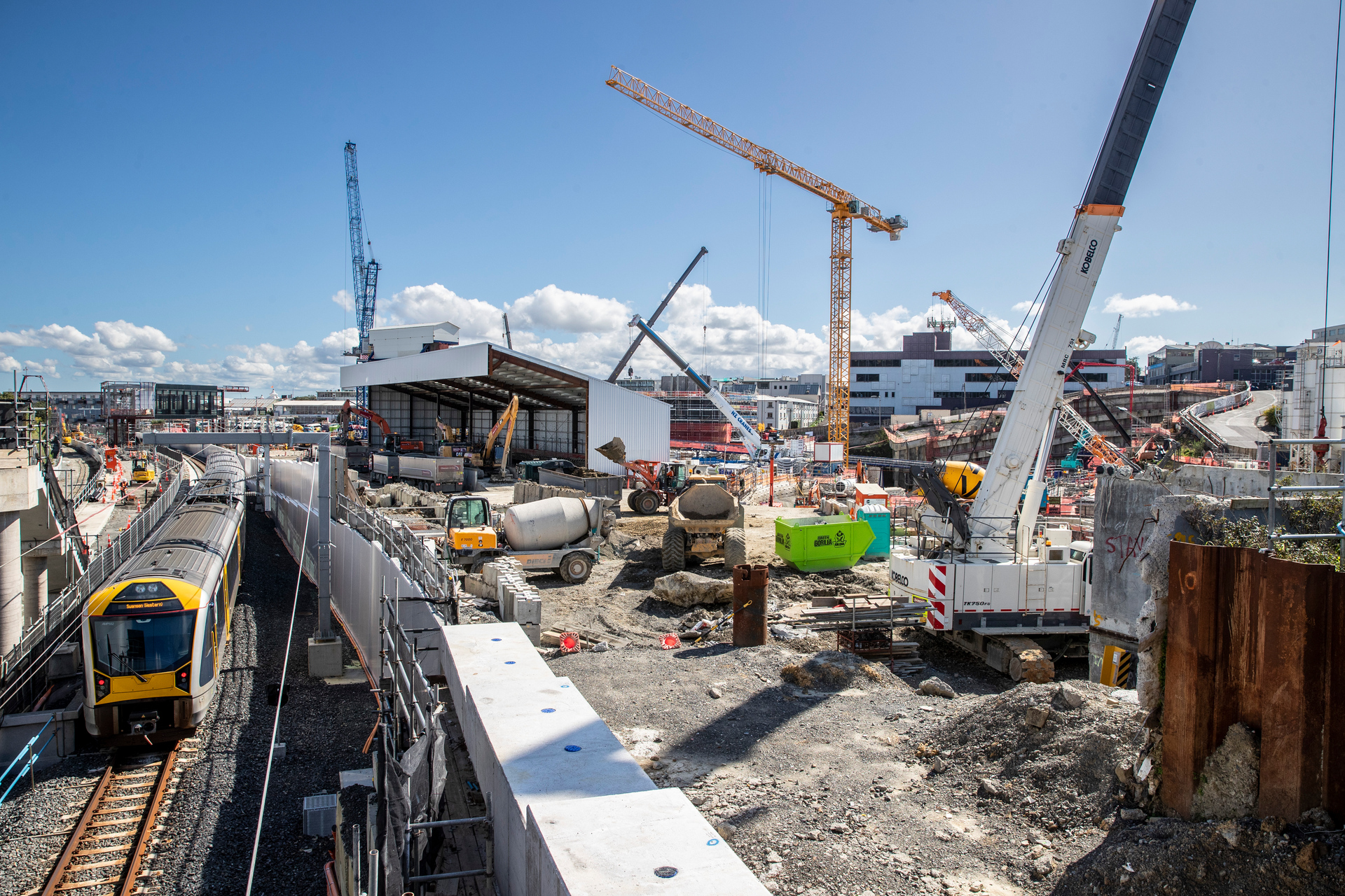 A train at leaft passes the construction site for what will be the Maungawhau/Mount Eden Station on the City Rail Link. Photo / Michael Craig