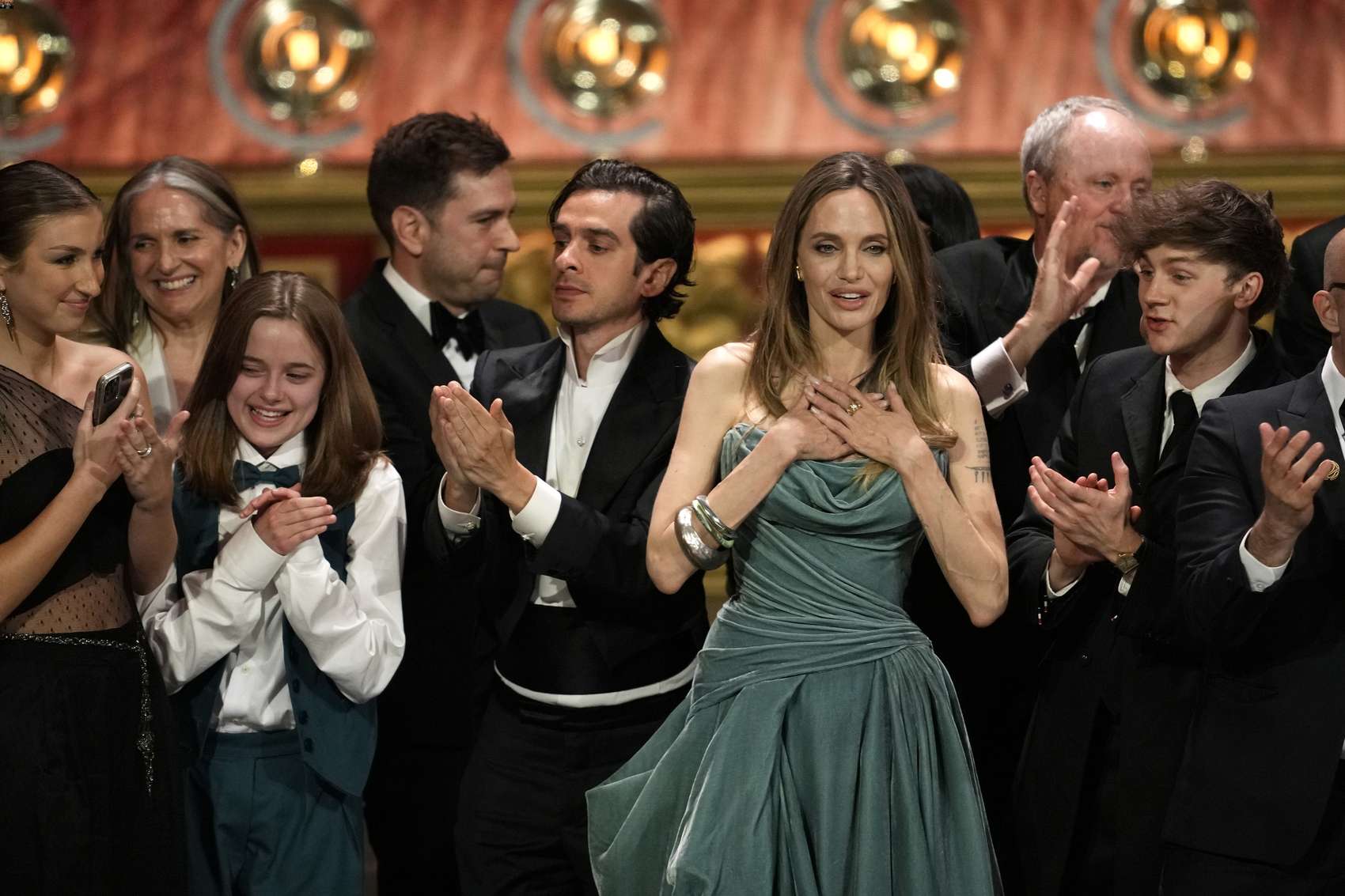 Vivienne Jolie-Pitt, Justin Levine, Angelina Jolie, Brody Grant and members of the company of The Outsiders accept the award for best musical during the 77th Tony Awards. Photo / AP