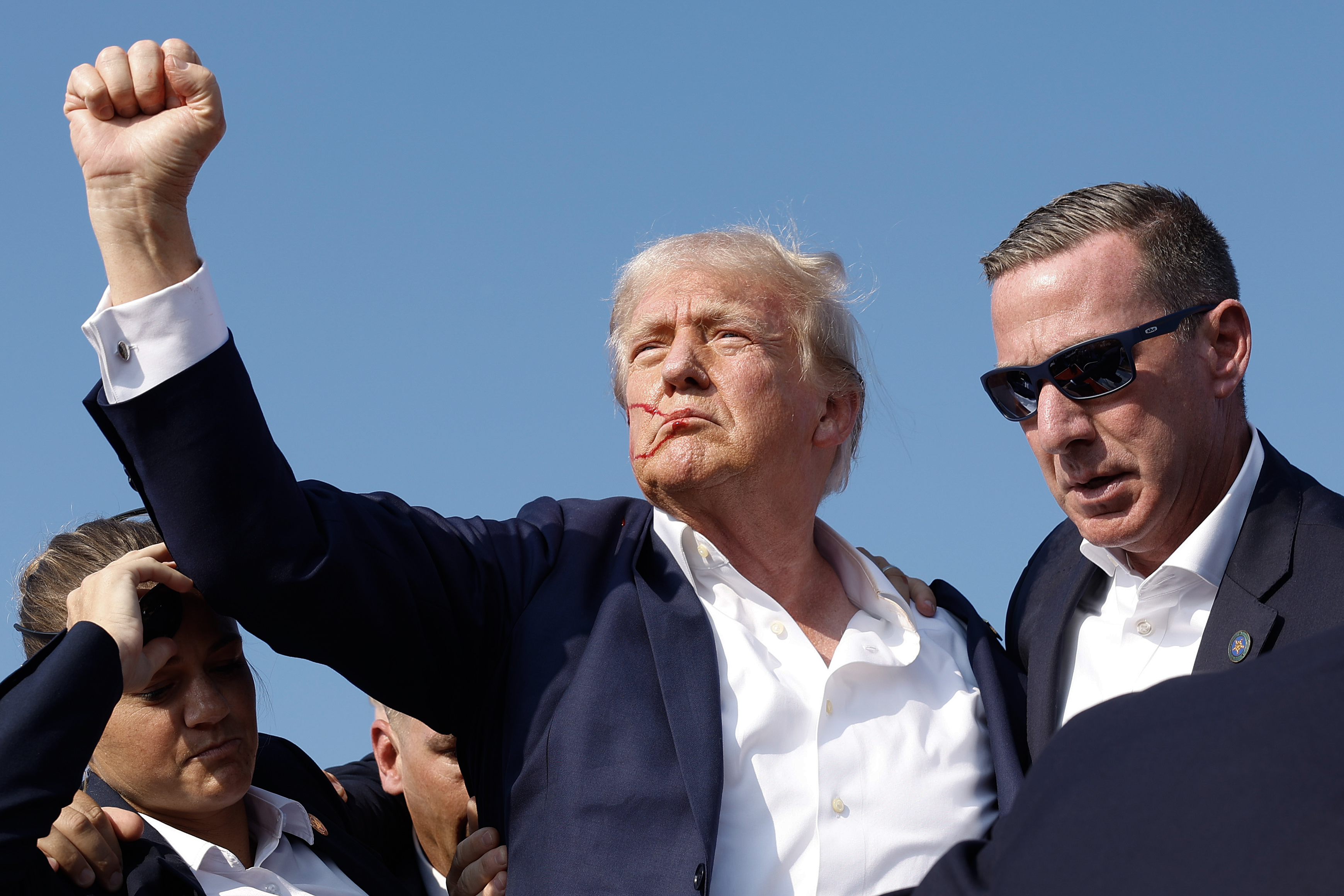 Republican presidential candidate former President Donald Trump pumps his fist as he is rushed off stage after the shooting. Photo / Getty Images