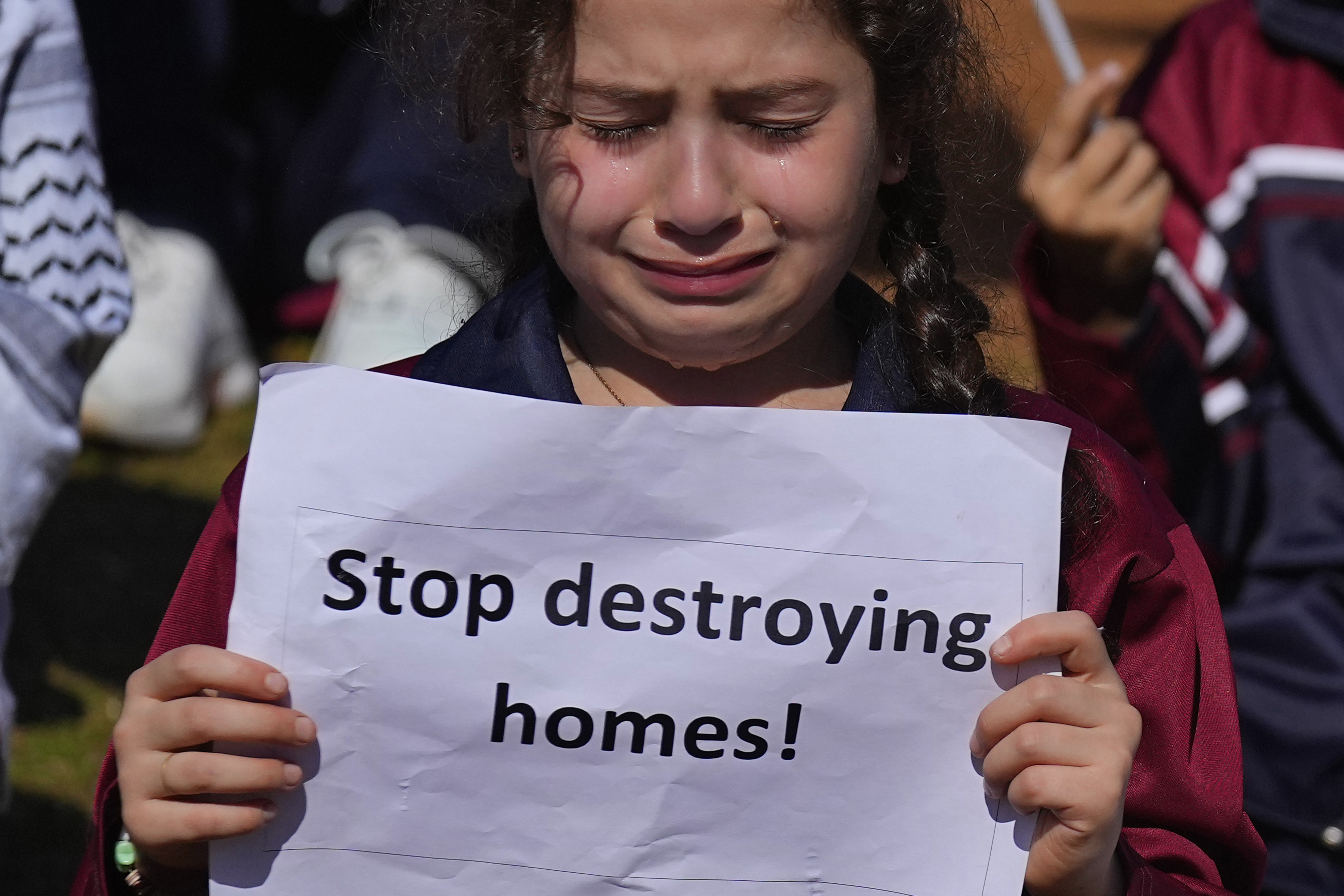 A girl weeps as she holds a placard during a protest against Israel's attack on the Gaza Strip, in front of the headquarters of the UN. Photo / AP