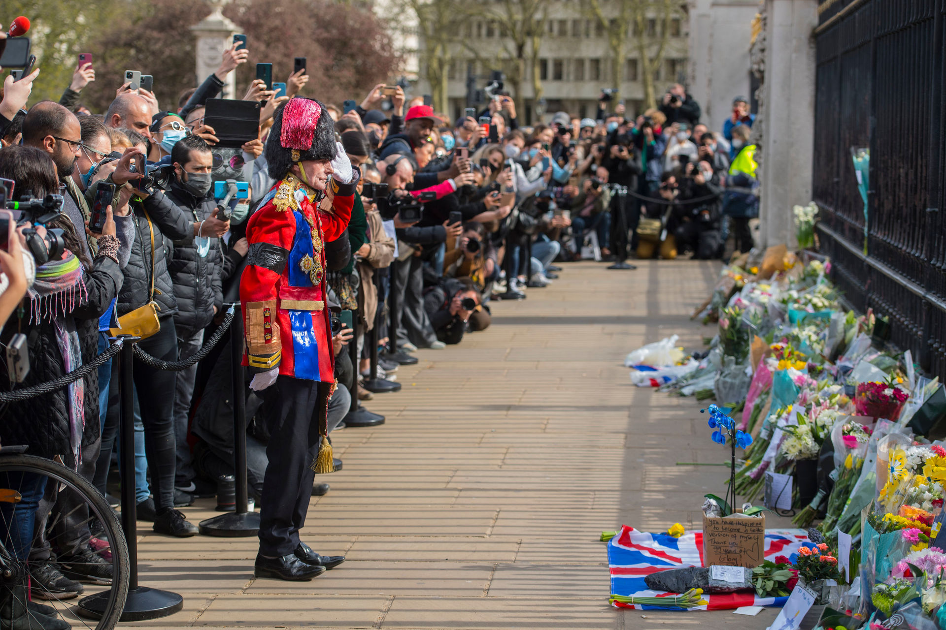 A man arrives to lay a floral tribute outside Buckingham Palace, London. Photo / AP