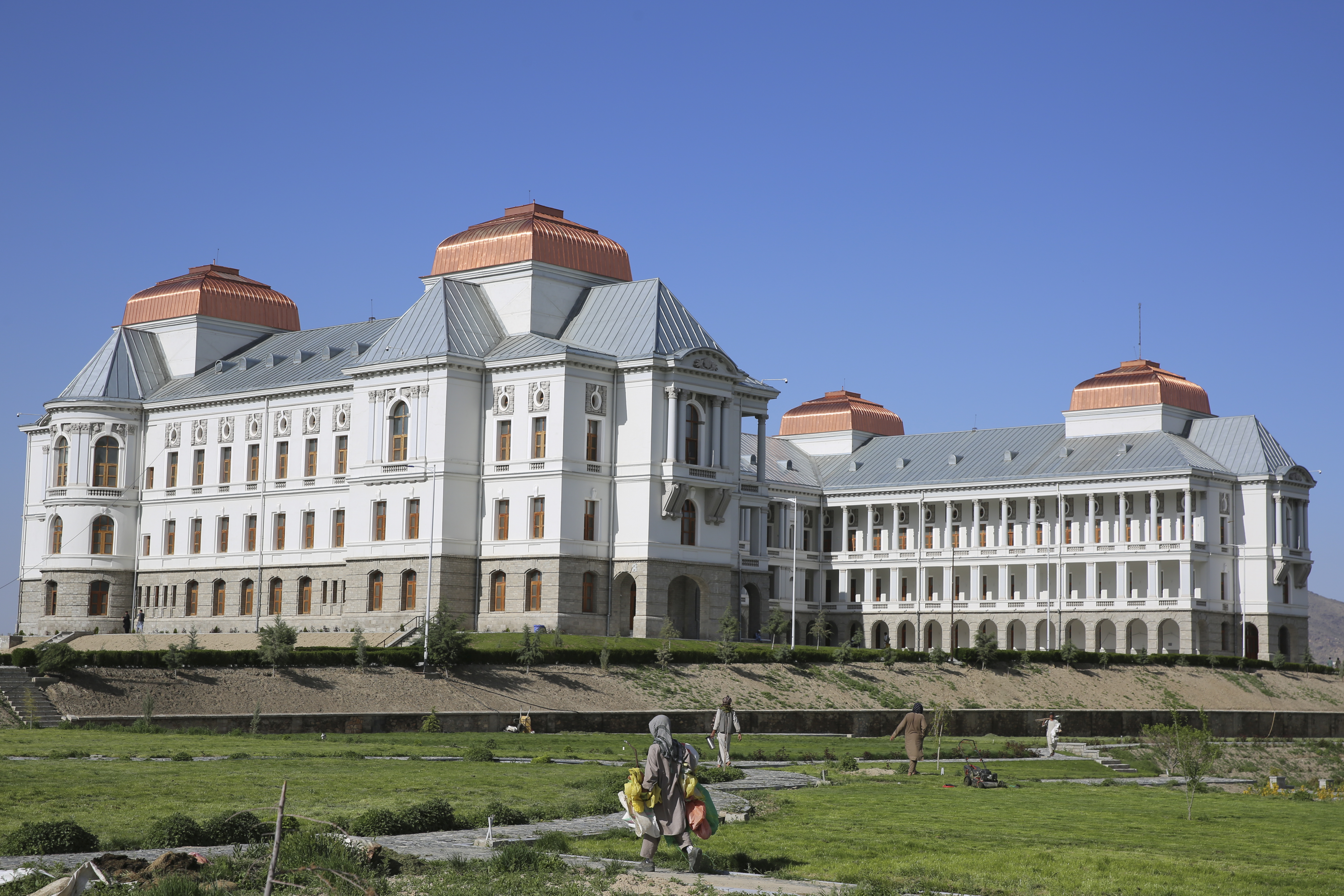 Afghans work in the garden of the renovated Darul Aman Palace in Kabul, Afghanistan. Photo / AP