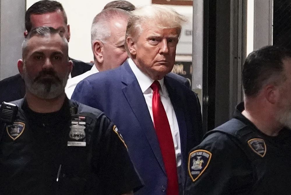 Former President Donald Trump is escorted to a courtroom. Photo / AP