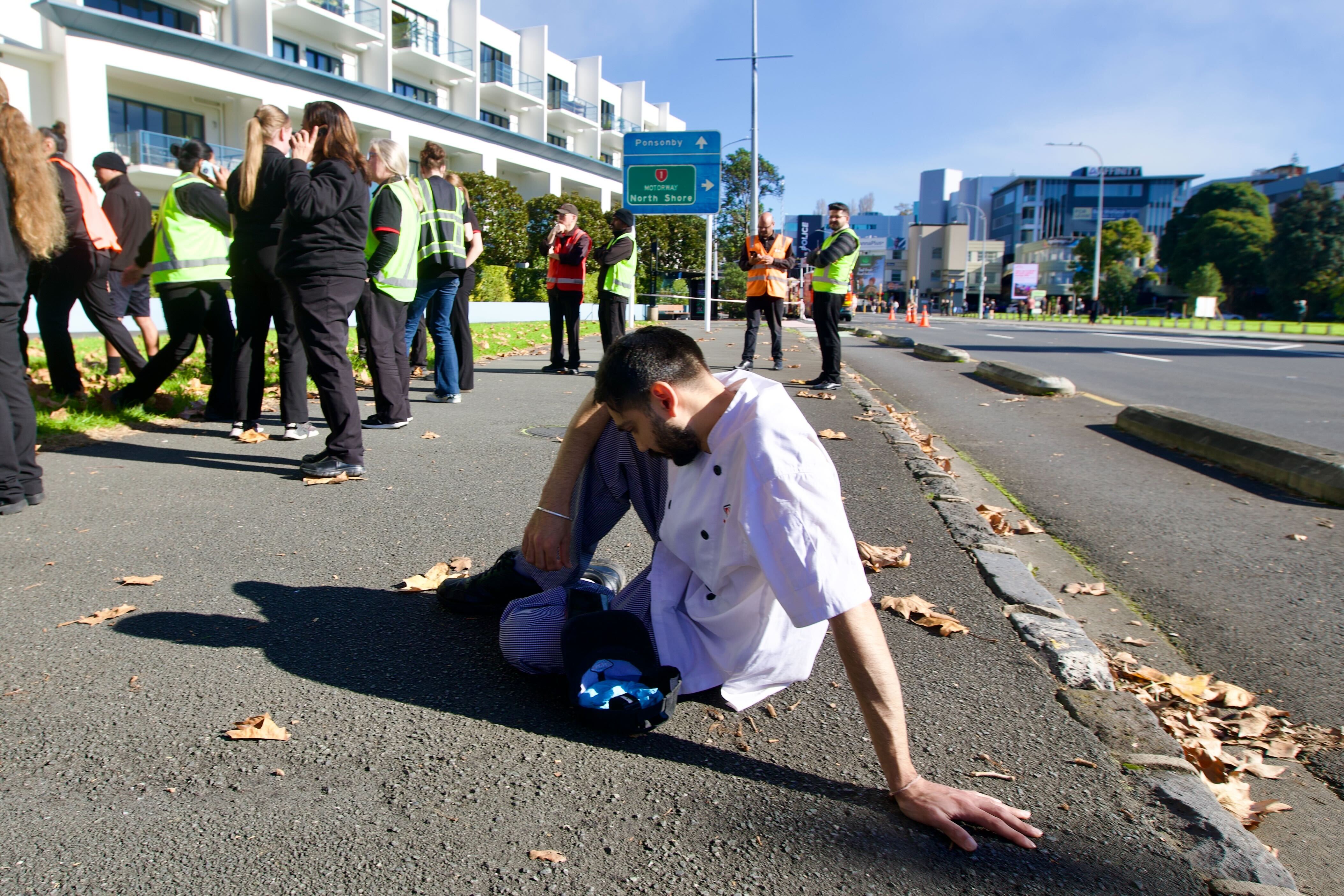 A worker rests after evacuating. Photo / Jason Dorday.