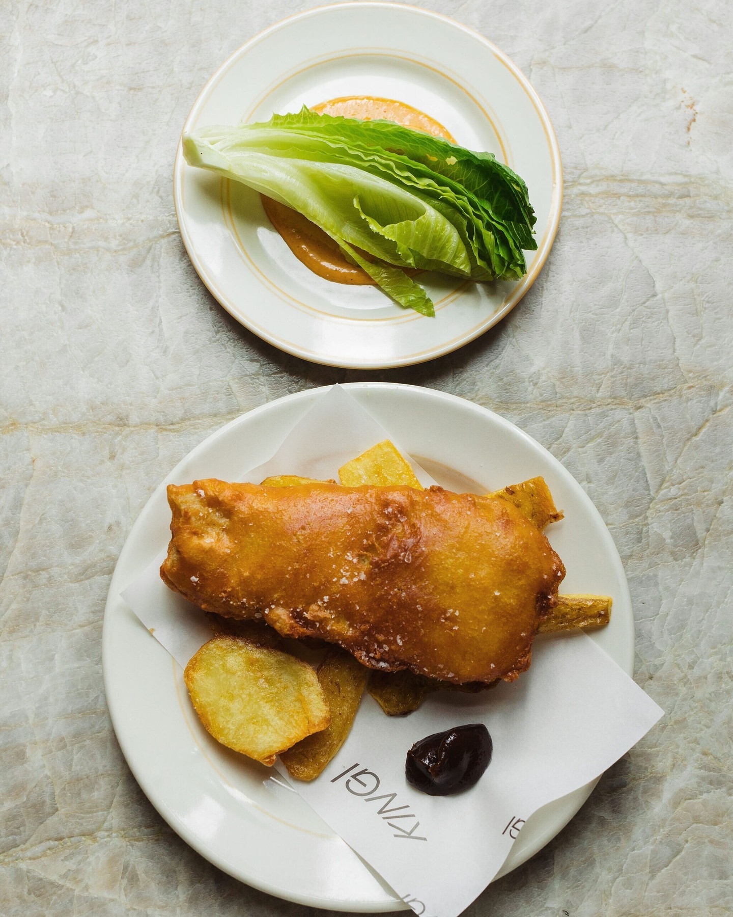Kingi's battered gurnard with potato skins, baby cos, curried mayonnaise and tomato sauce. Photo / @Kingi_britomart