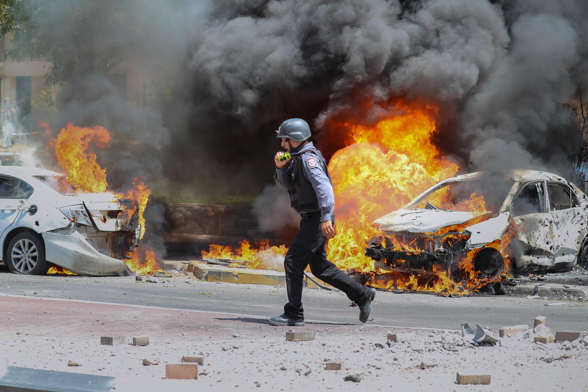 An Israeli firefighter walks past cars hit by a missile fired from Gaza Strip, in the southern Israeli town of Ashkelon, in May 2021. Photo / Ariel Schalit, AP, File