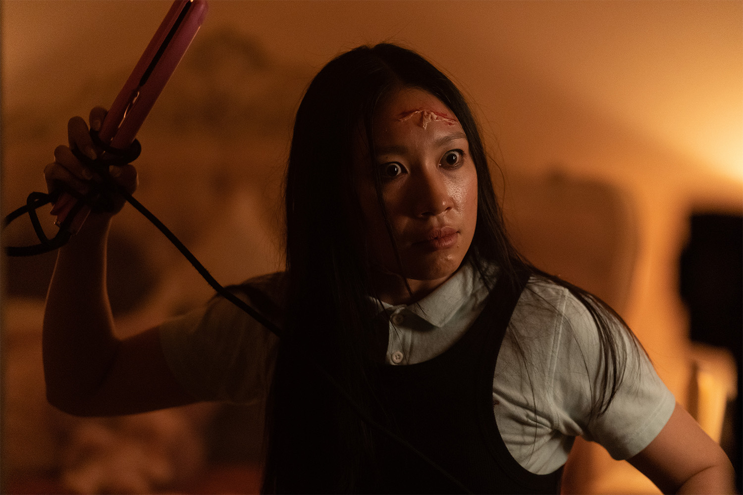 Jess Hong, who plays Angela, wields a hair straightener. 