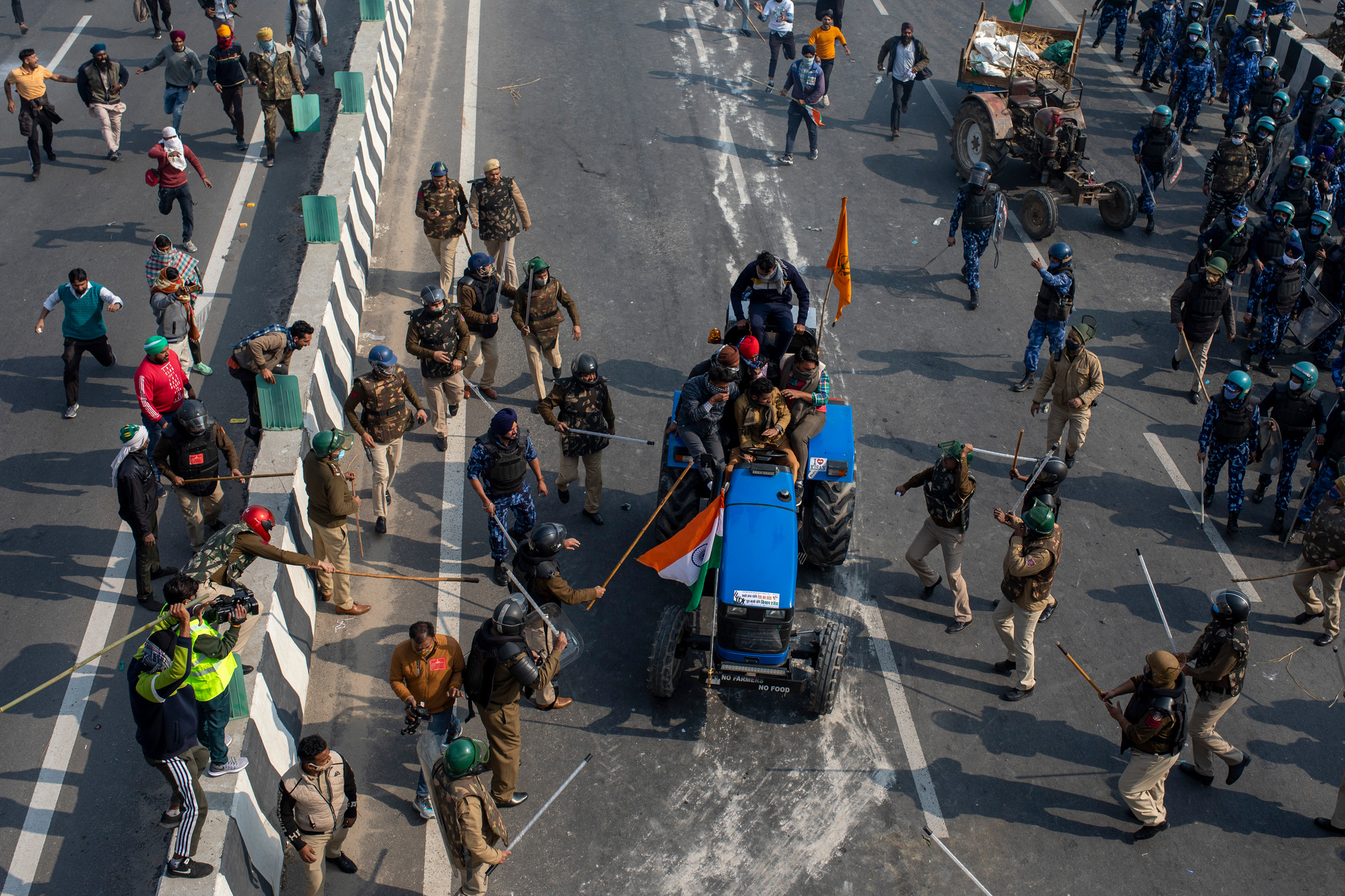 Indian policemen beat farmers driving a tractor towards the heart of the city as a sign of protest against new farm laws, during India's Republic Day. Photo / AP