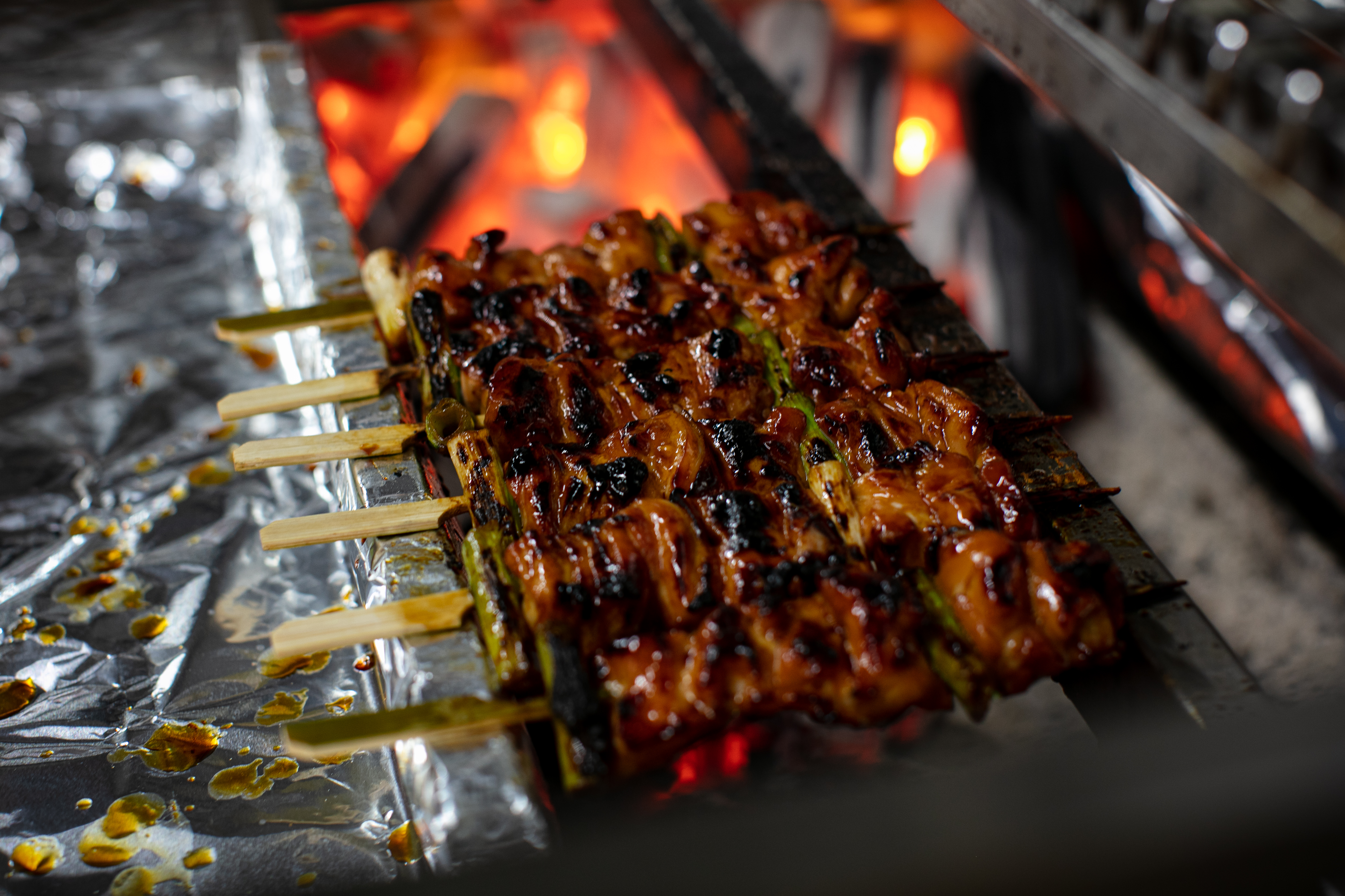 The chicken skewers cooking above the hot charcoal. Photo / Babiche Martens