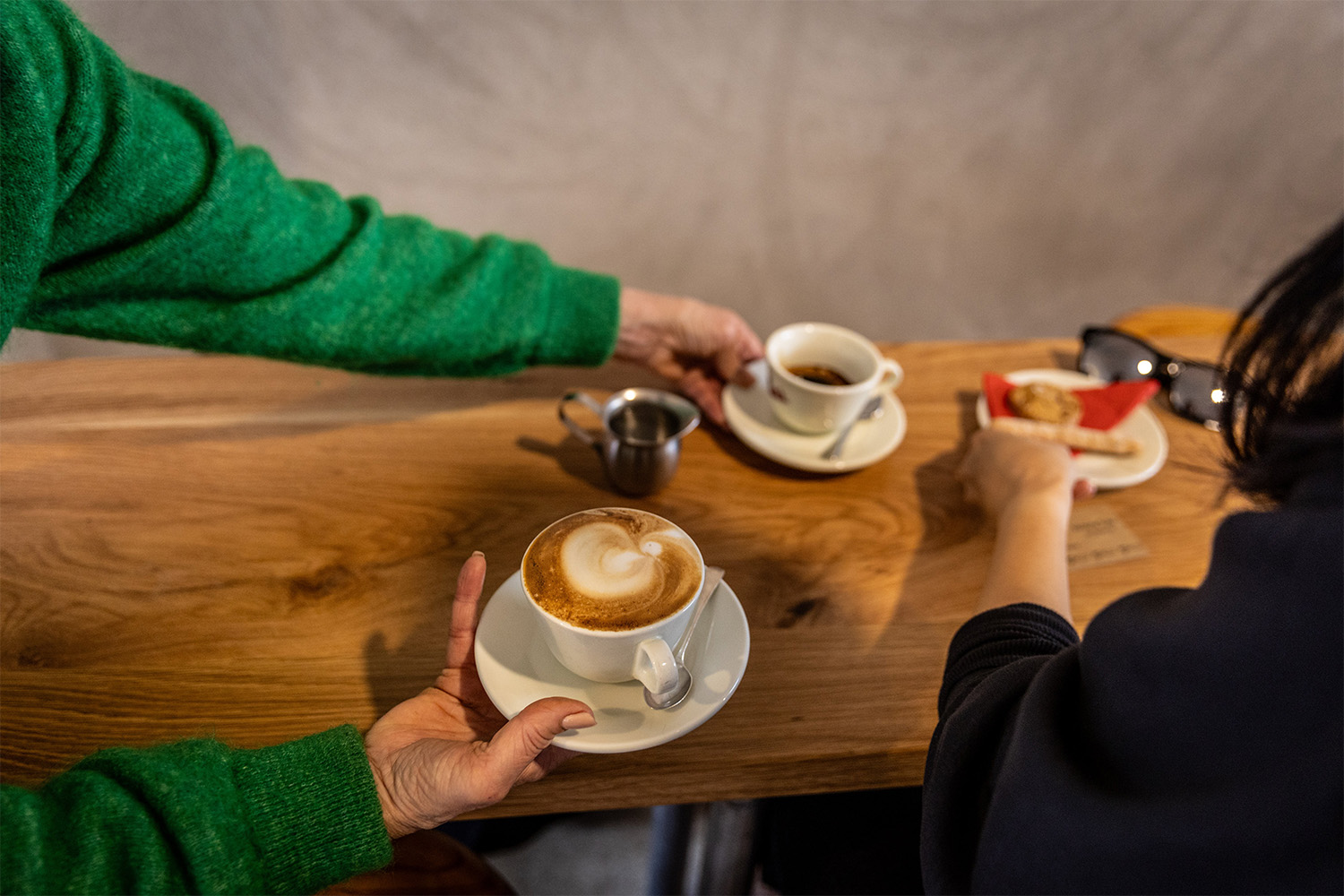 Victoria serves a flat white, with an accompanying espresso shot and a couple of cookies, to a waiting customer. Photo / Michael Craig