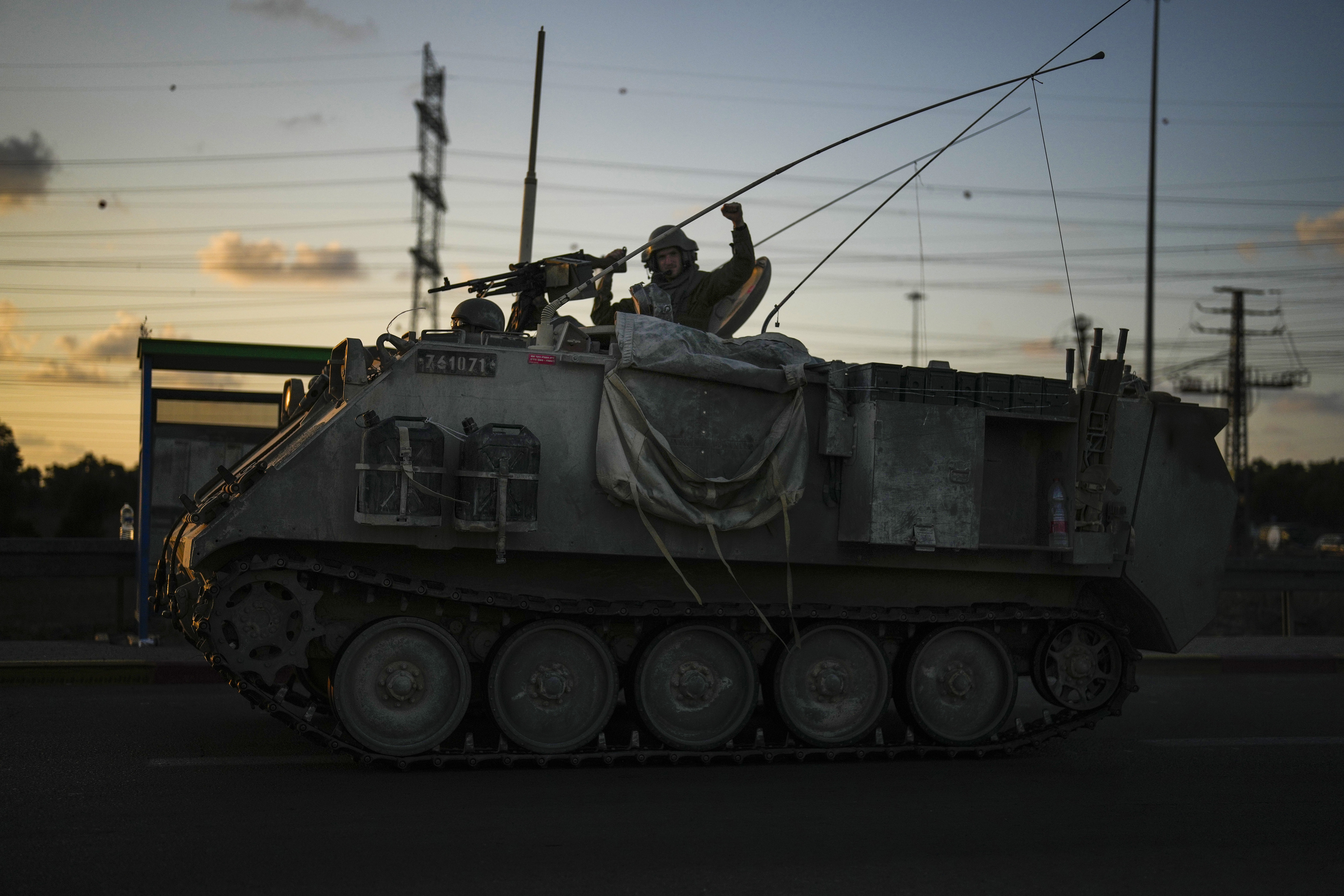 An Israeli soldier gestures to passersby as he drives a military vehicle near the border between Israel and Gaza Strip, Israel. Photo / AP