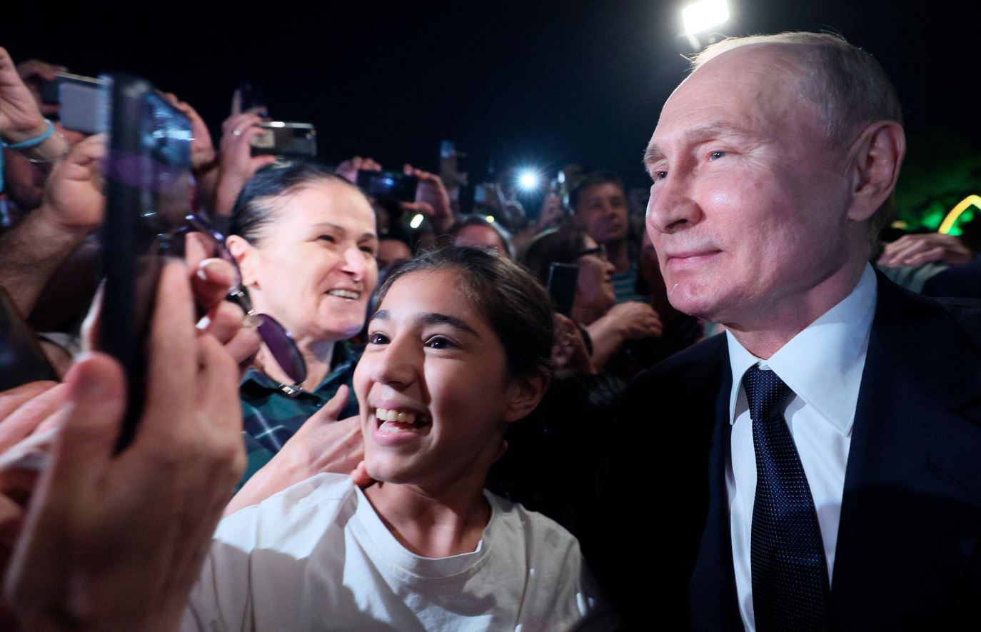 Vladimir Putin (right) poses for a selfie during his visit to Derbent in Dagestan, Russia. Photo / AP