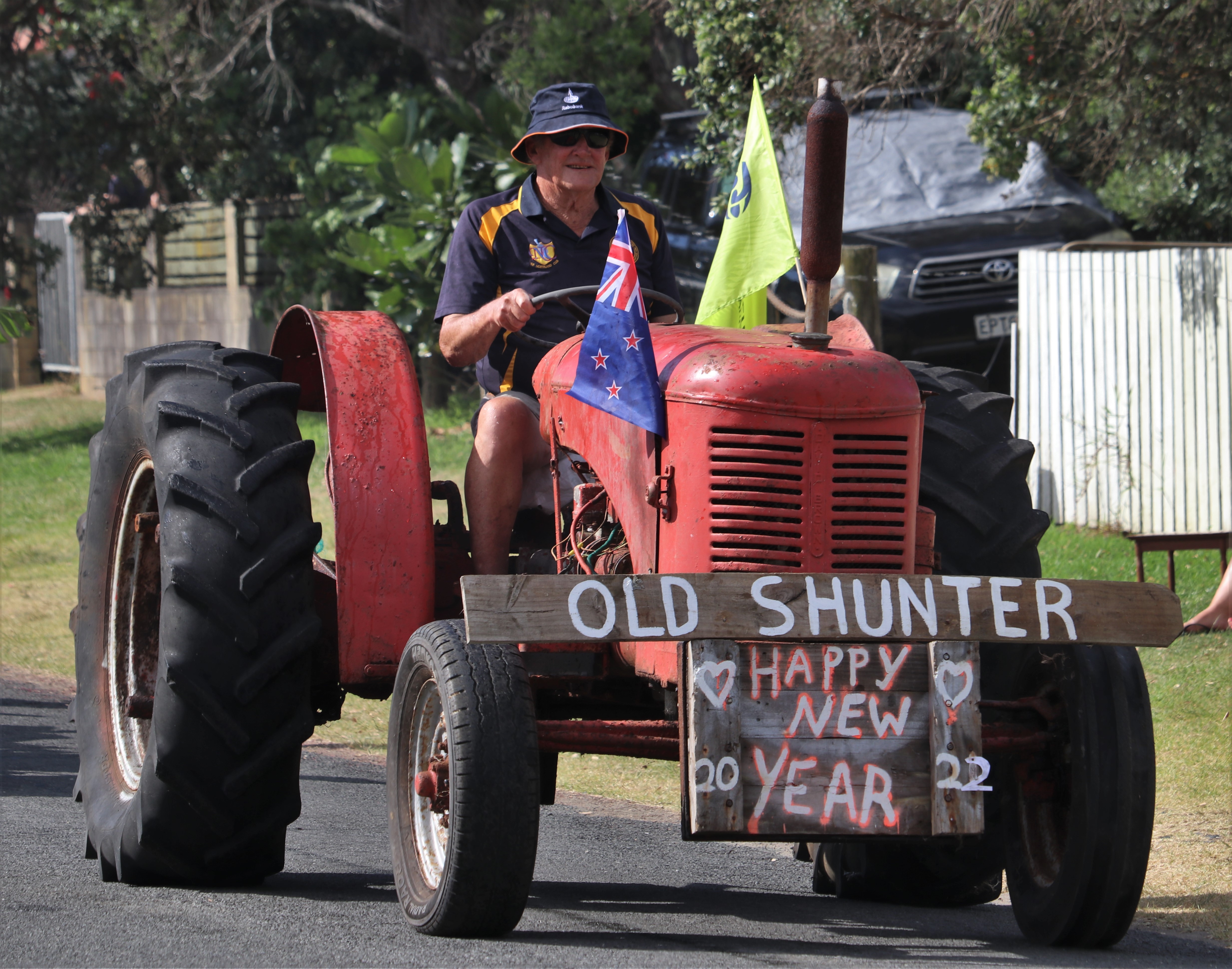 A vintage tractor known as Old Shunter chugs down Taupō Bay’s main drag. Photo / Peter de Graaf
