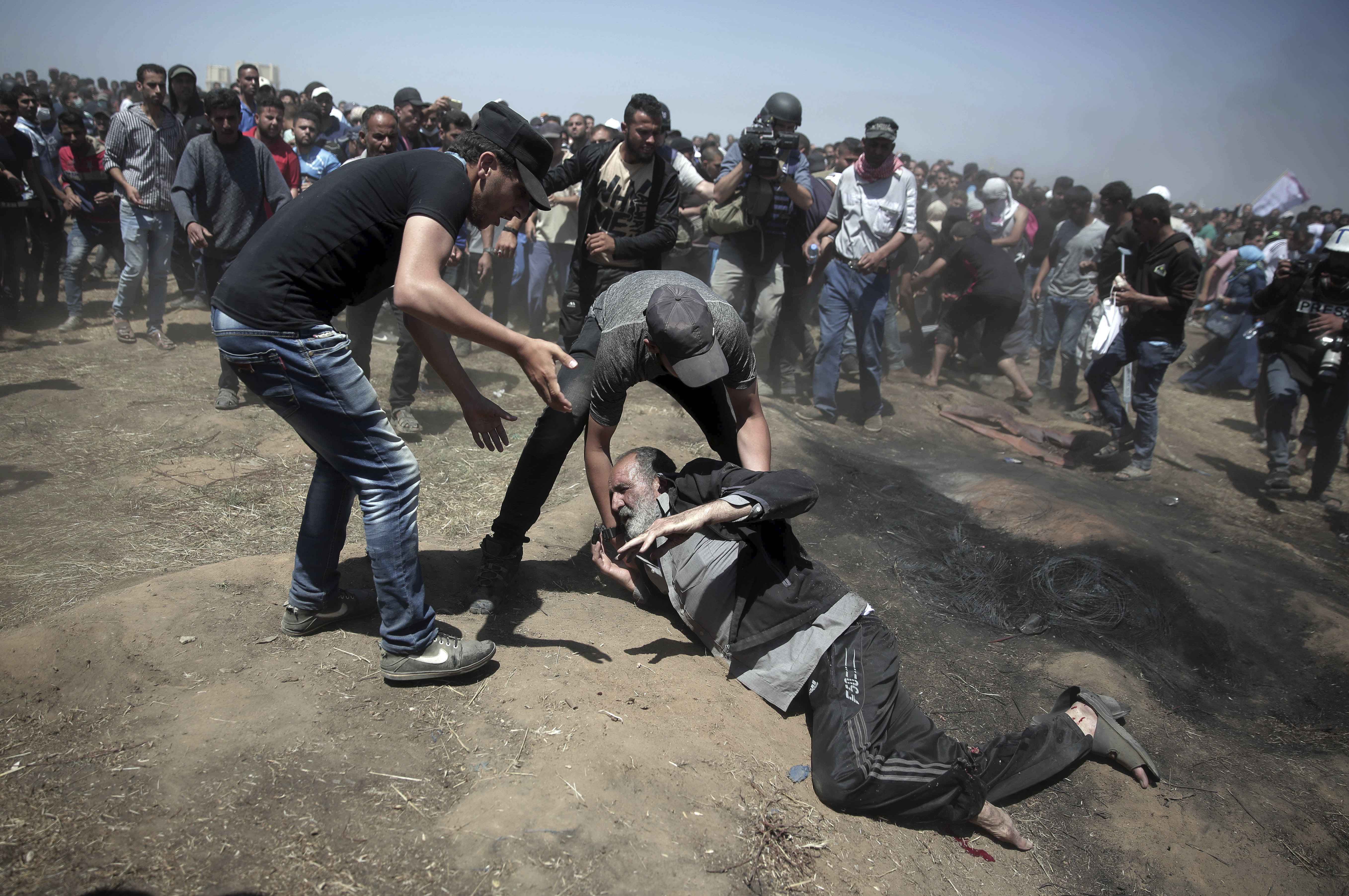 An elderly Palestinian man falls on the ground after being shot by Israeli troops during a deadly protest at the Gaza Strip's border with Israel. Photo / AP 