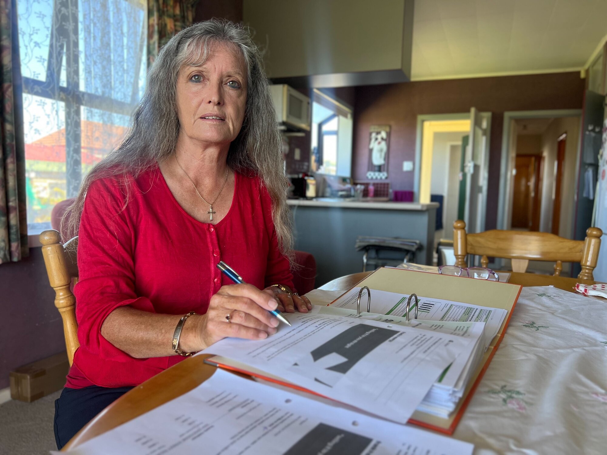 Sharon Sutton at her home in Hastings with the records she has kept regarding her electricity over the years. Photo / Rafaella Melo