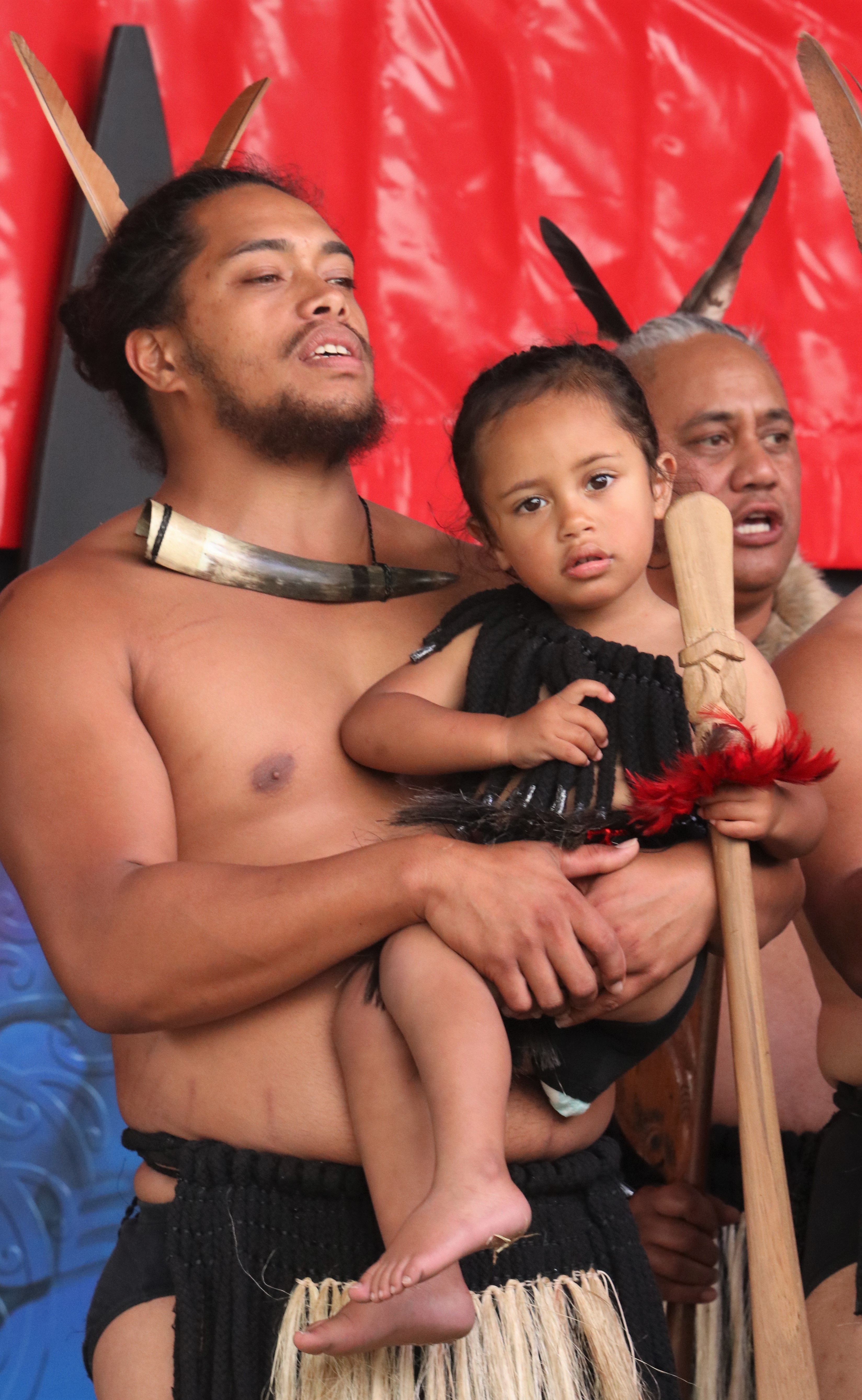 Hamiora Tautu holds his two-year-old son Tumata-Rauiri Eruera Waitai-Henare Tautu during a performance by Muriwhenua kapa haka group. Photo / Peter de Graaf