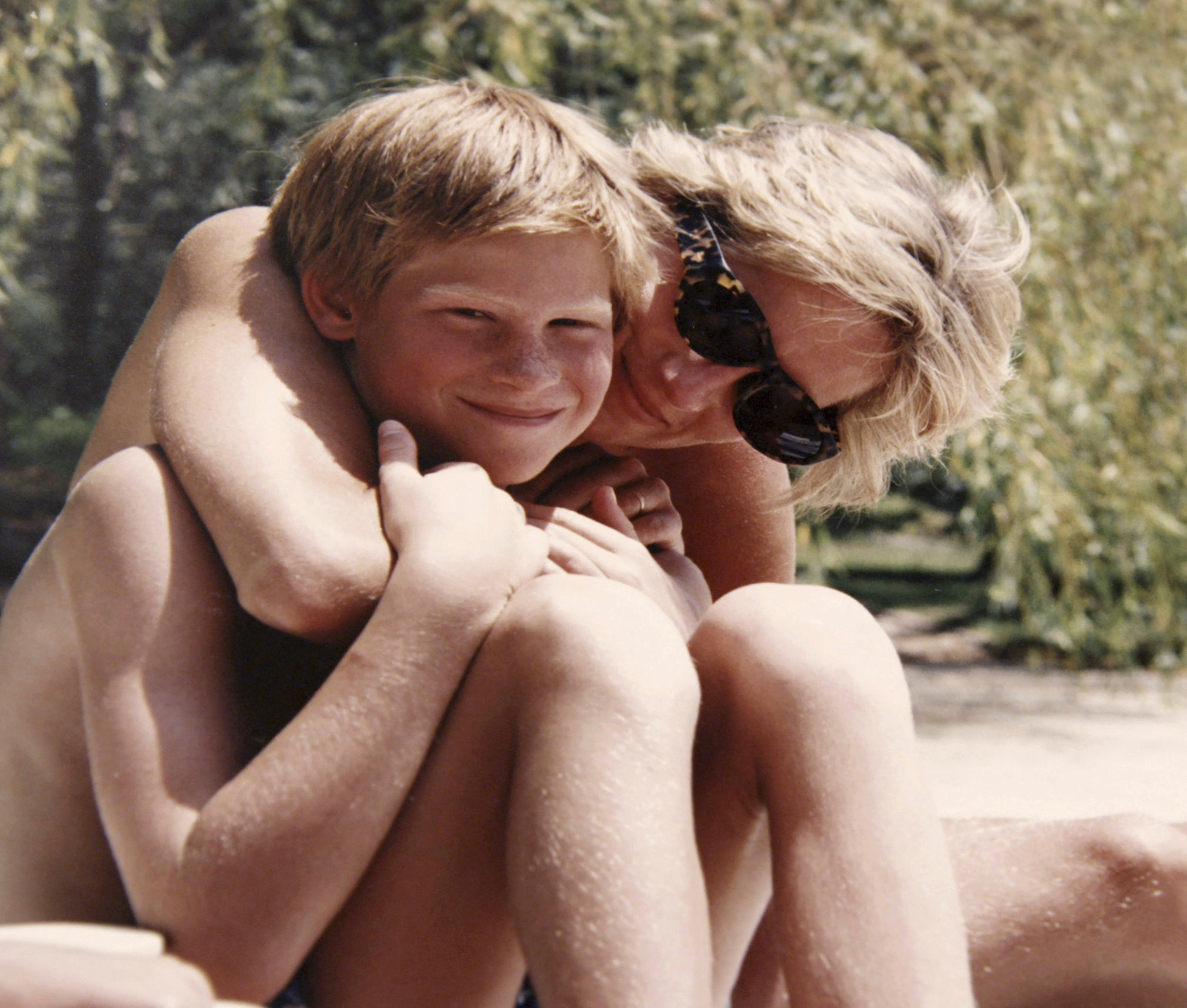 Sitting in the sunshine, wrapped in his mother's embrace, Prince Harry beams with blissful delight in one of the last images of mother and son together. Photo / Getty Images