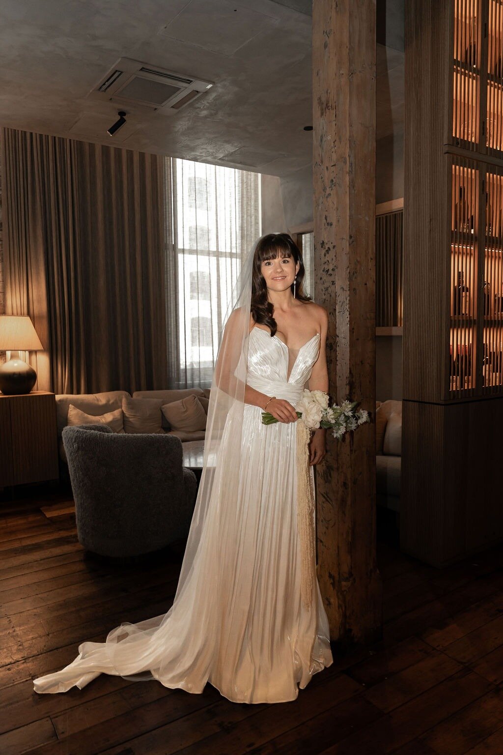 Hannah wears the Hailey: 'Hand-pleated bodice with a deep, measured plunge, flowing into a skirt of liquid, vertical folds.' Photo / Supplied
