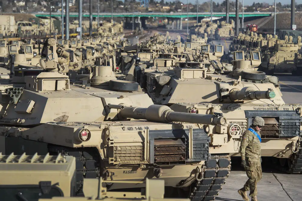 A soldier walks past a line of M1 Abrams tanks. Photo / AP