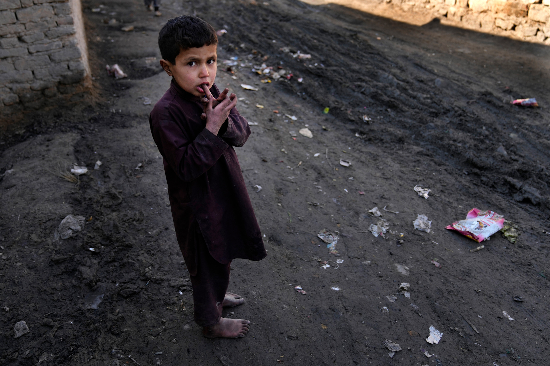 A barefoot boy stands in a muddy alley in Kabul, Afghanistan. Photo / AP