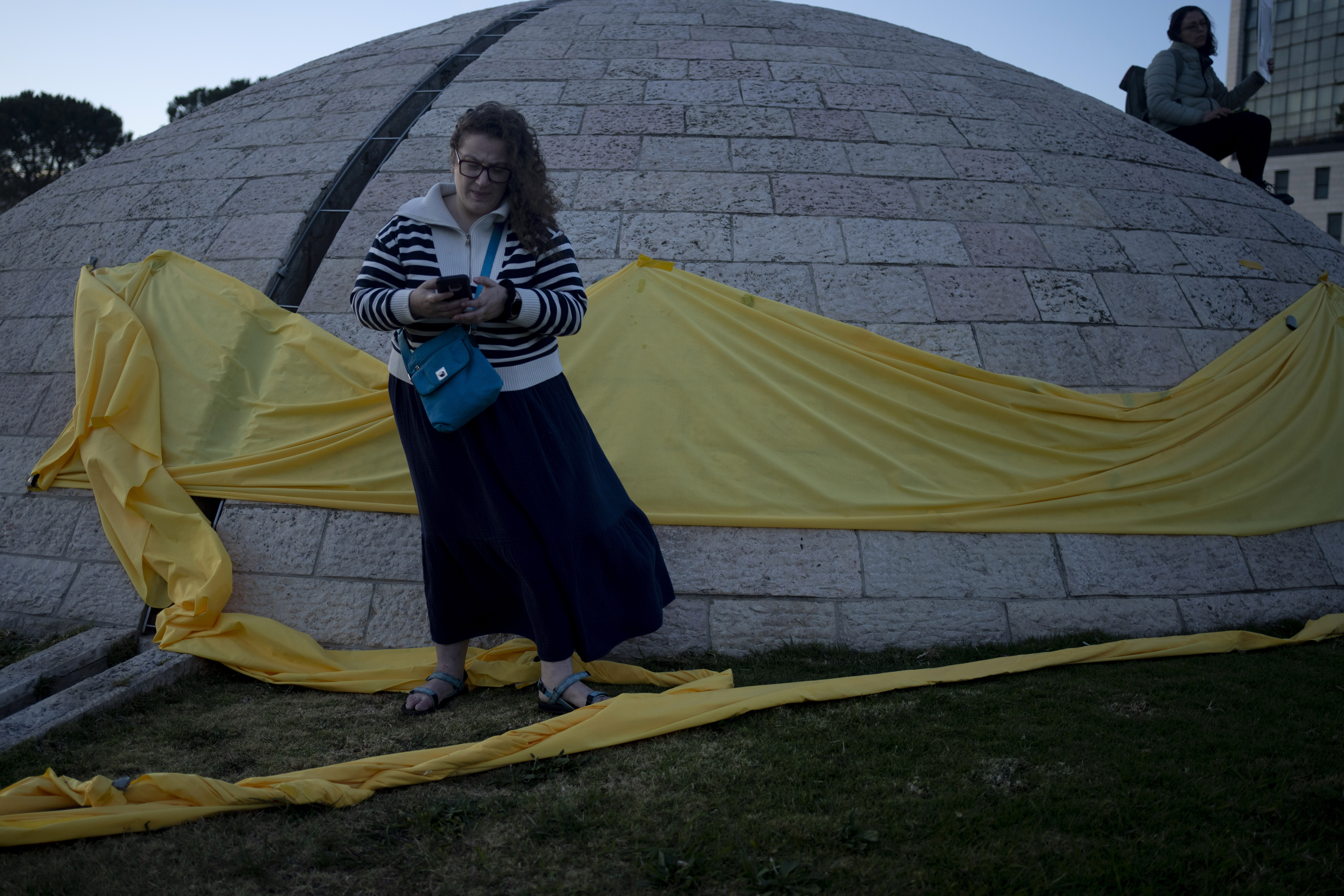 Yellow cloth is draped around an architectural feature as relatives of hostages held in Gaza and their supporters protest. Photo / AP