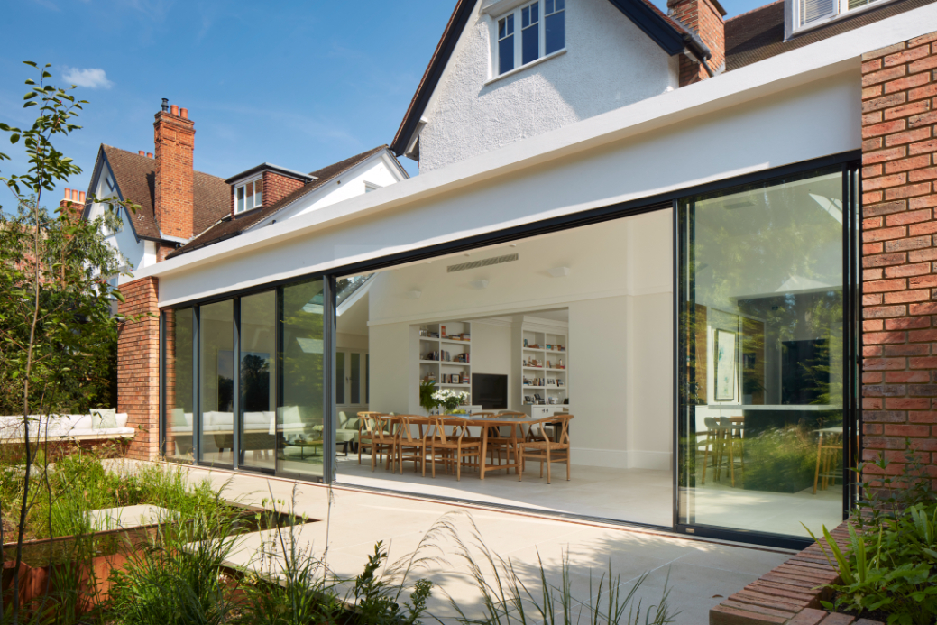 The external brickwork features recessed pointing and extends into the garden to create seamless outdoor seating.