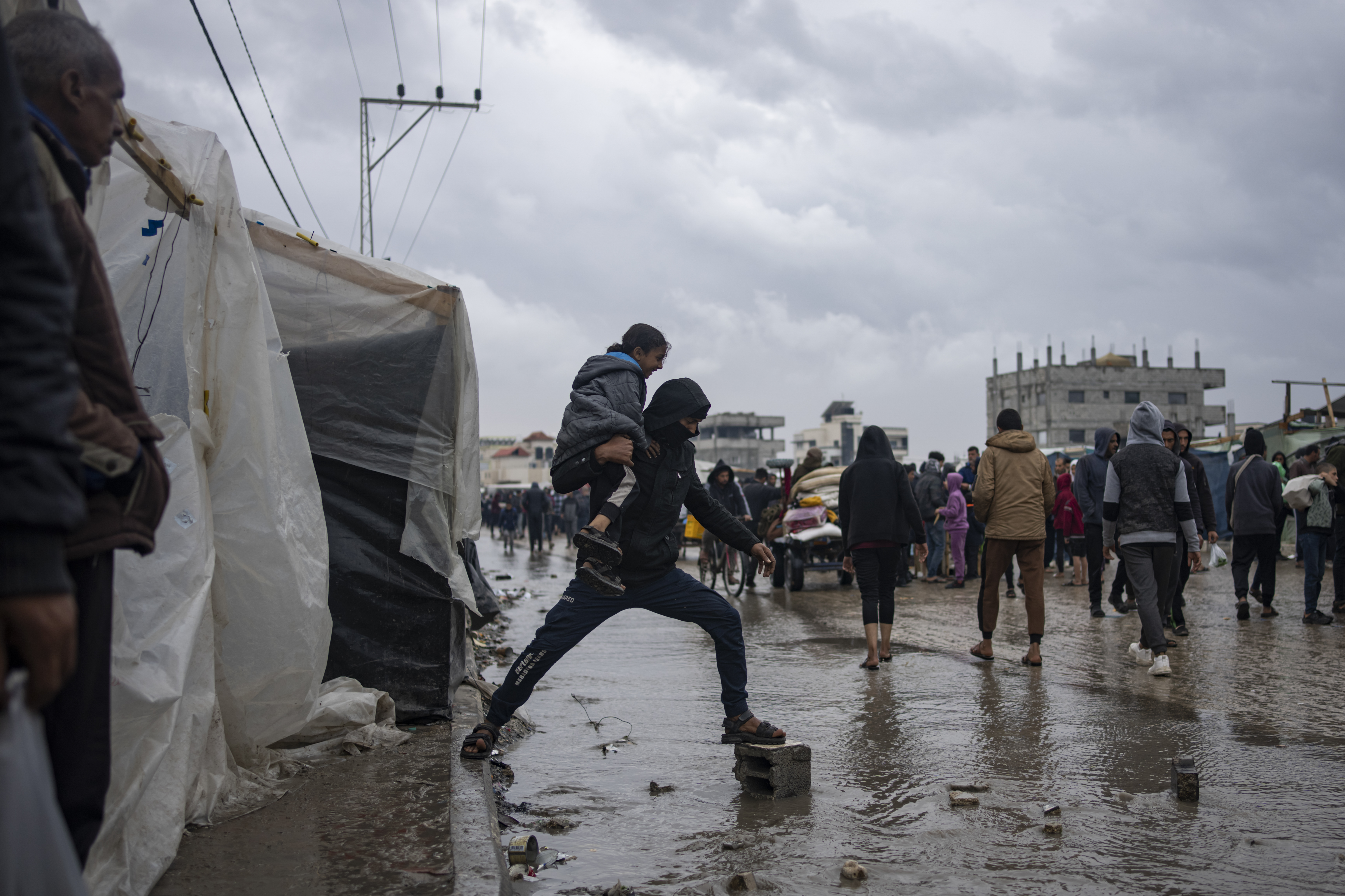 Palestinians displaced by the Israeli air and ground offensive on the Gaza Strip walk through a makeshift tent camp in Rafah on Saturday. Photo / AP 