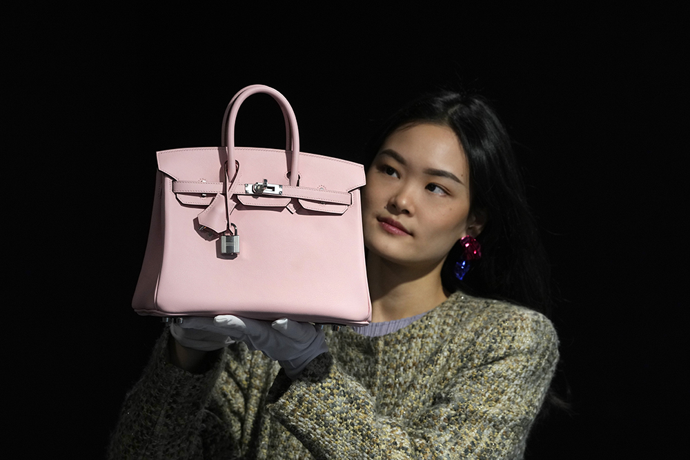 A Bonhams employee displays a Hermes Rose Sakura Swift Leather Birkin 25 bag at the auction rooms in London. Photo / AP