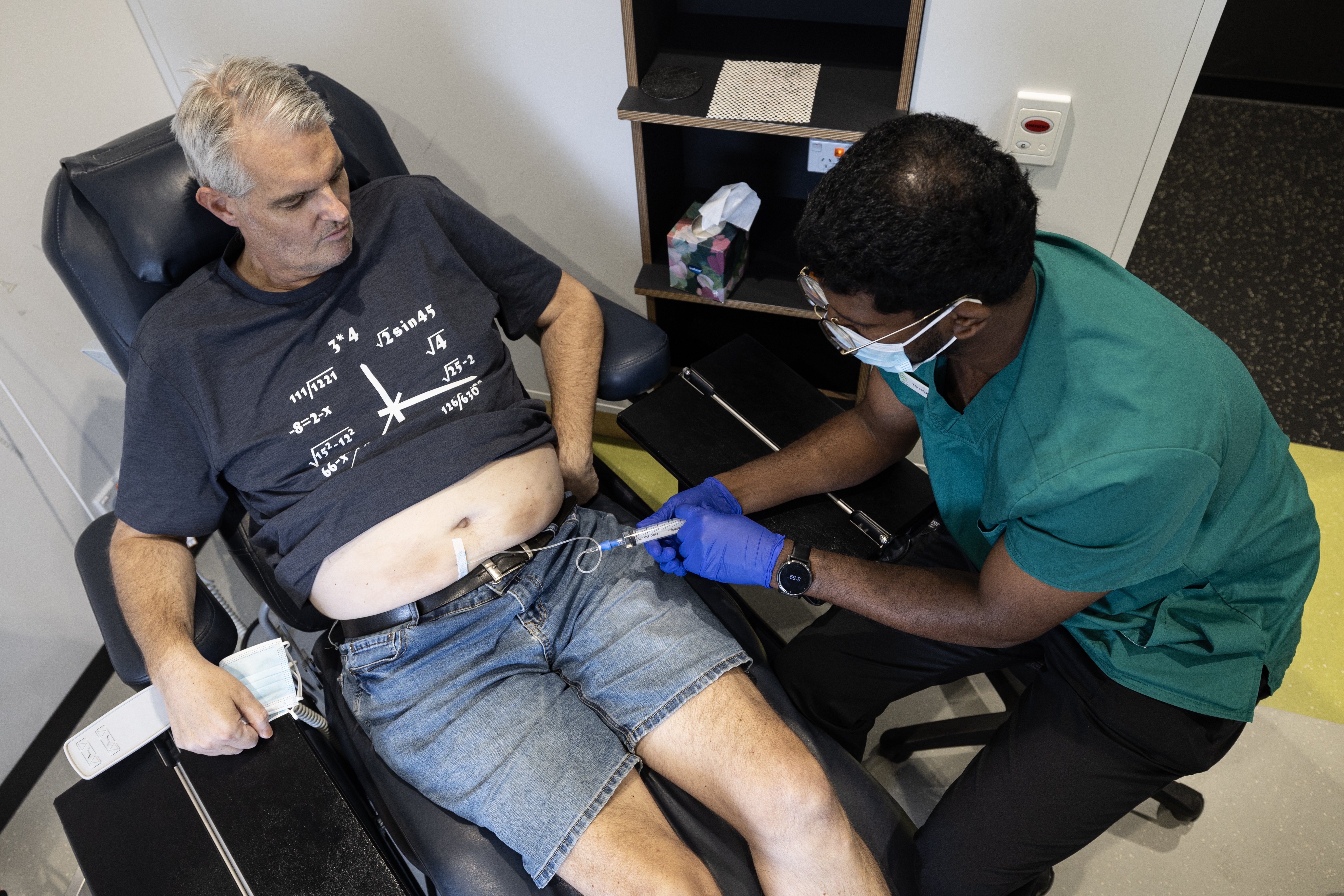 Simon Clark receives his daratumumab drug treatment for myeloma blood cancer with the aid of clinical nurse specialist Kaveendra Krishna, at a Canopy Cancer Care clinic in Takapuna. Photo / Jason Oxenham