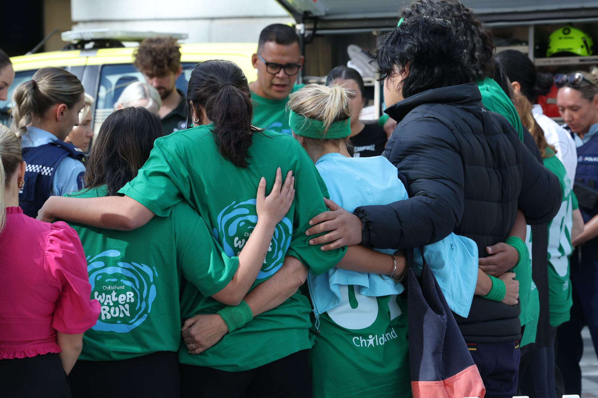 Participants and organisers embrace at the scene after Efeso Collins collapsed.