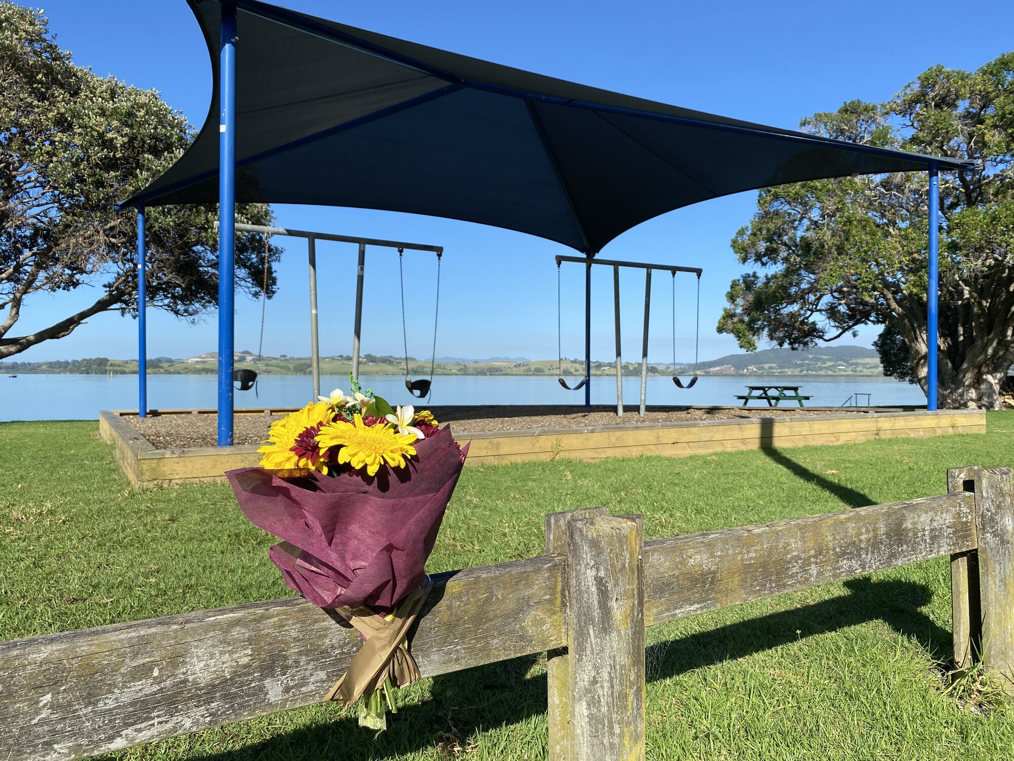 Flowers were laid at Beach Road Reserve in Onerahi the day after the shooting. Photo / Denise Piper