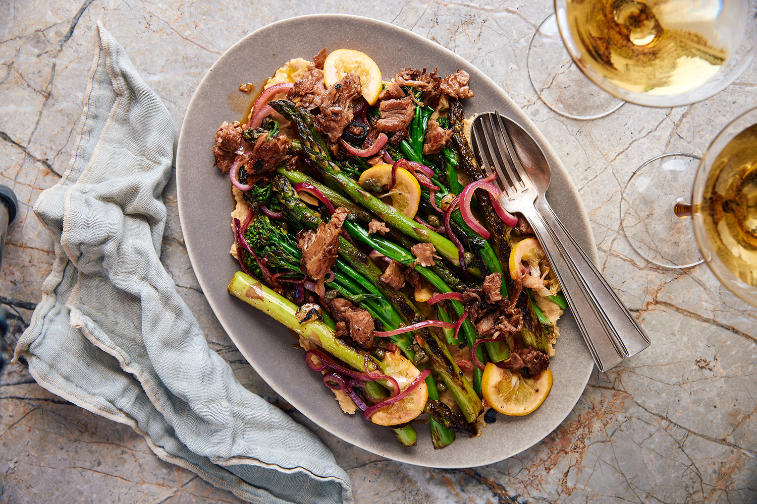 Marinated broccoli is joined by seasonal asparagus, seared lemon slices and homemade hummus in this shared plate. Photo / Babiche Martens
