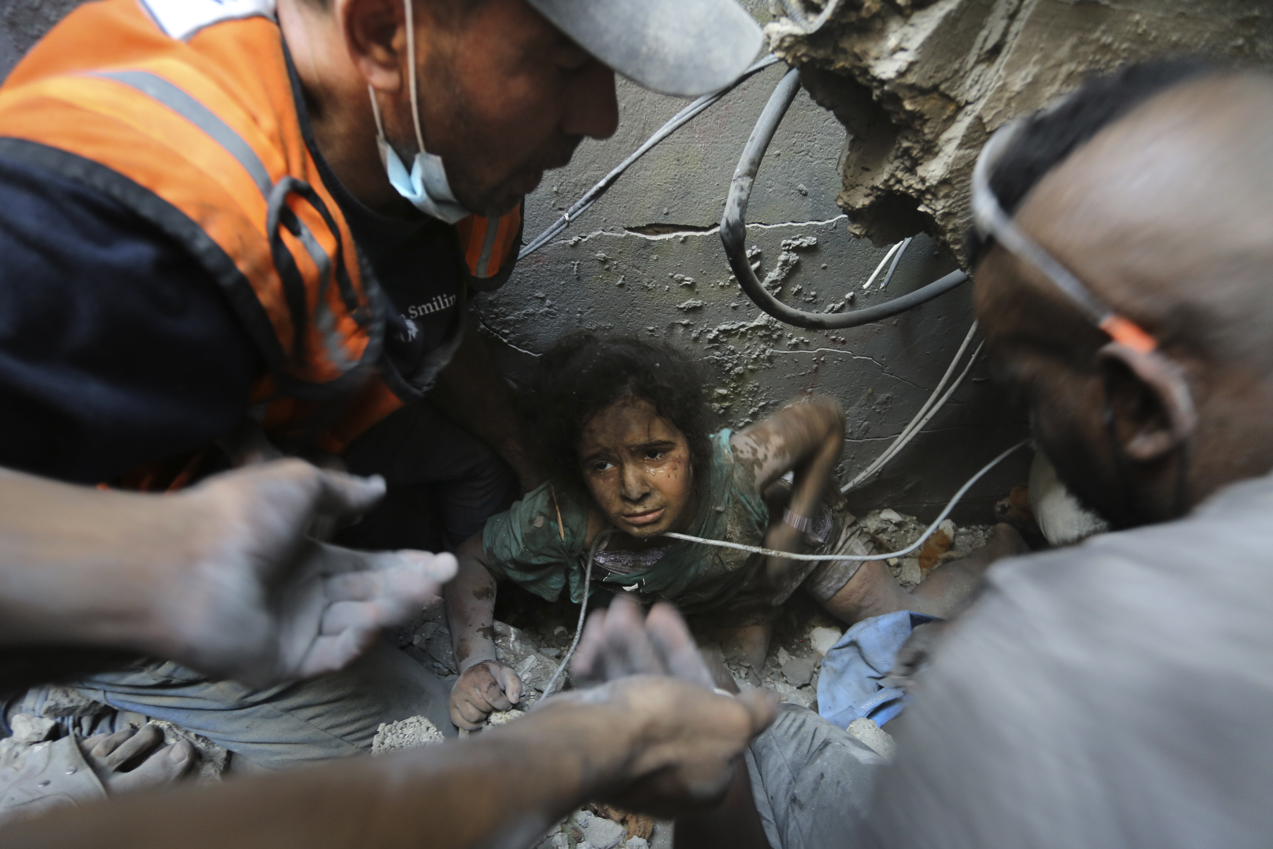 Palestinians try to pull a girl out of the rubble of a building that was destroyed by Israeli airstrikes in the Jabaliya refugee camp, part of the northern Gaza Strip. Photo / AP