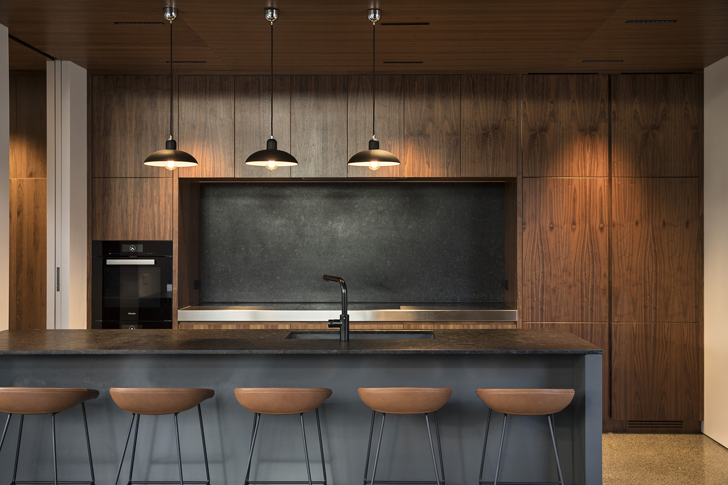 The kitchen counter and splashback are finished in honed granite. Photo / Simon Devitt