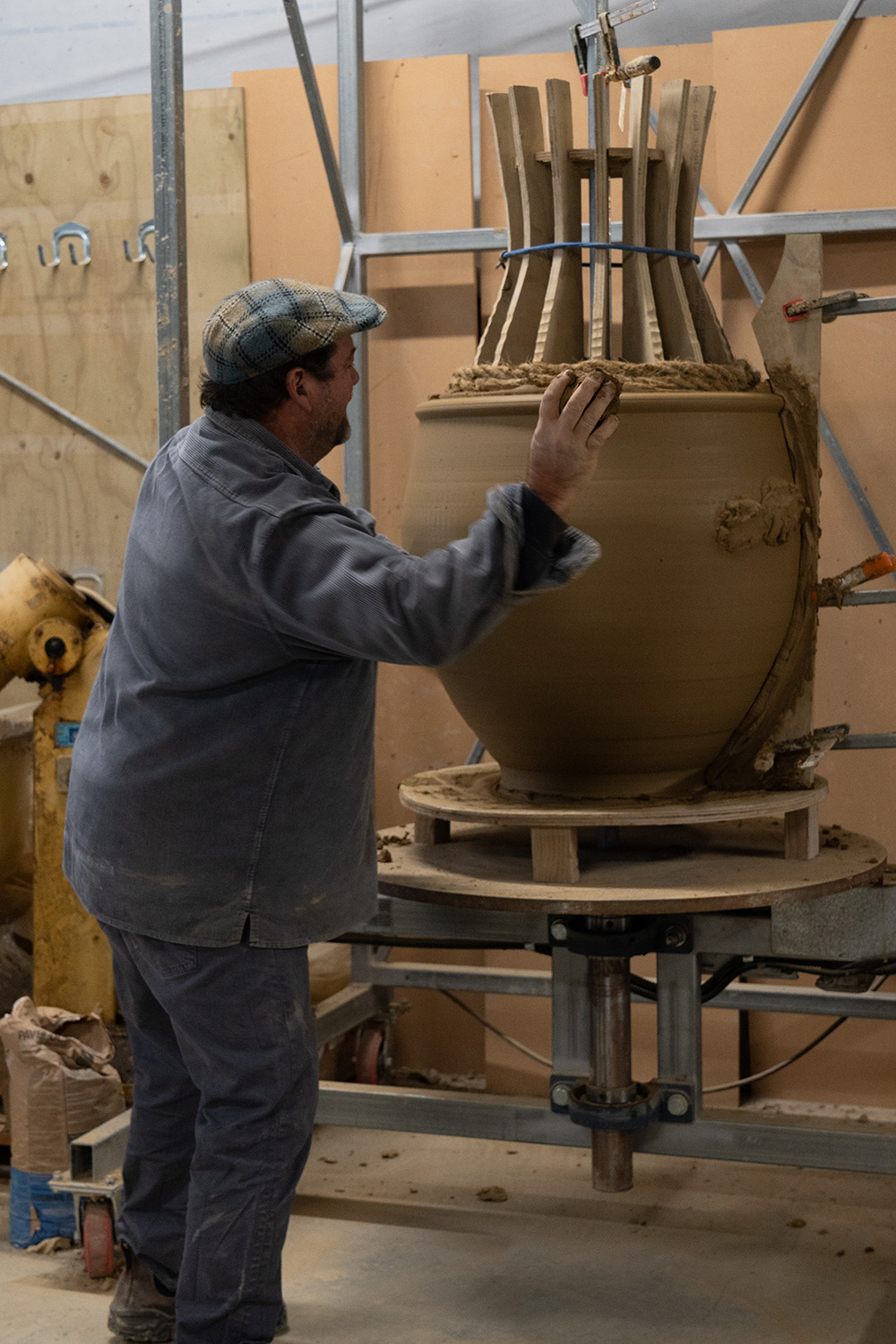 To make his large horticultural pots Yannick stands at a wheel suspended in a steel framework, and throws clay on to sisal ropes shaped with plywood formwork. It is very physical, and the pots are forklifted from wheel to kiln. Photo / Hyuma Kaneko