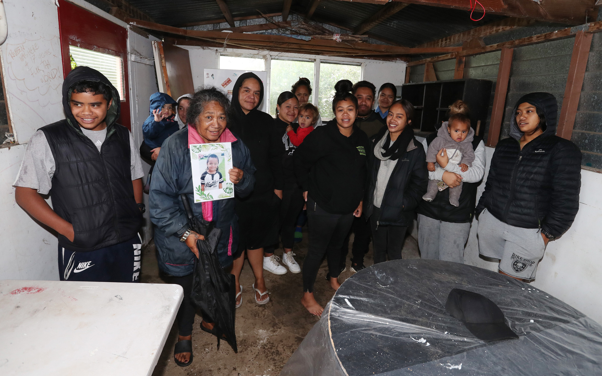 Most of the Ngakuru whānau group together in the garage of their new whare. Photo / Michael Cunningham