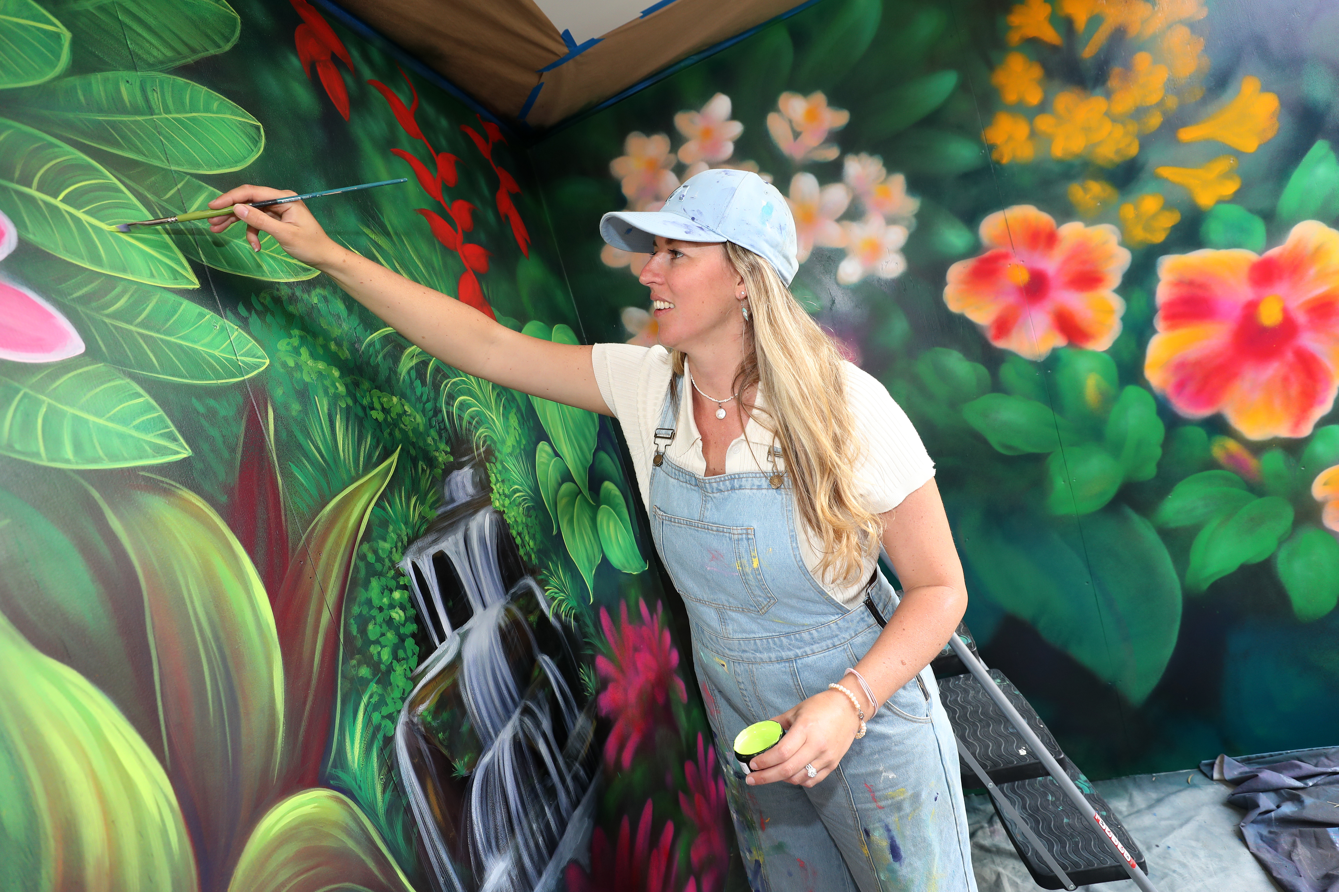 Kerikeri-based artist Erika Pearce creating a mural at Plant Zone Direct garden centre in Waipapa. Photo / Michael Cunningham