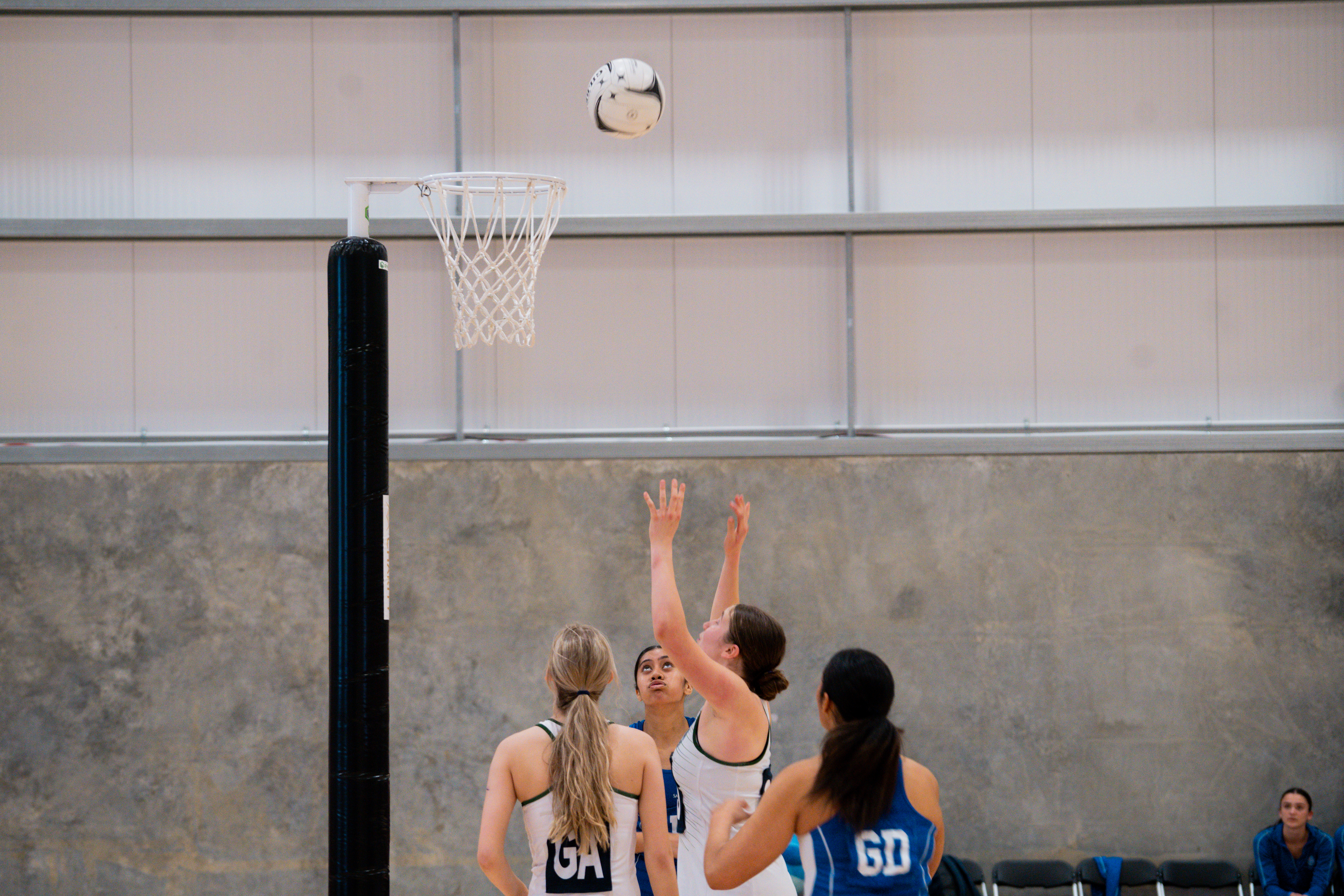 Columba College (white) taking on St Kentigern's during the group stages of the National Secondary Schools Netball Championship. Photo / Netball New Zealand
