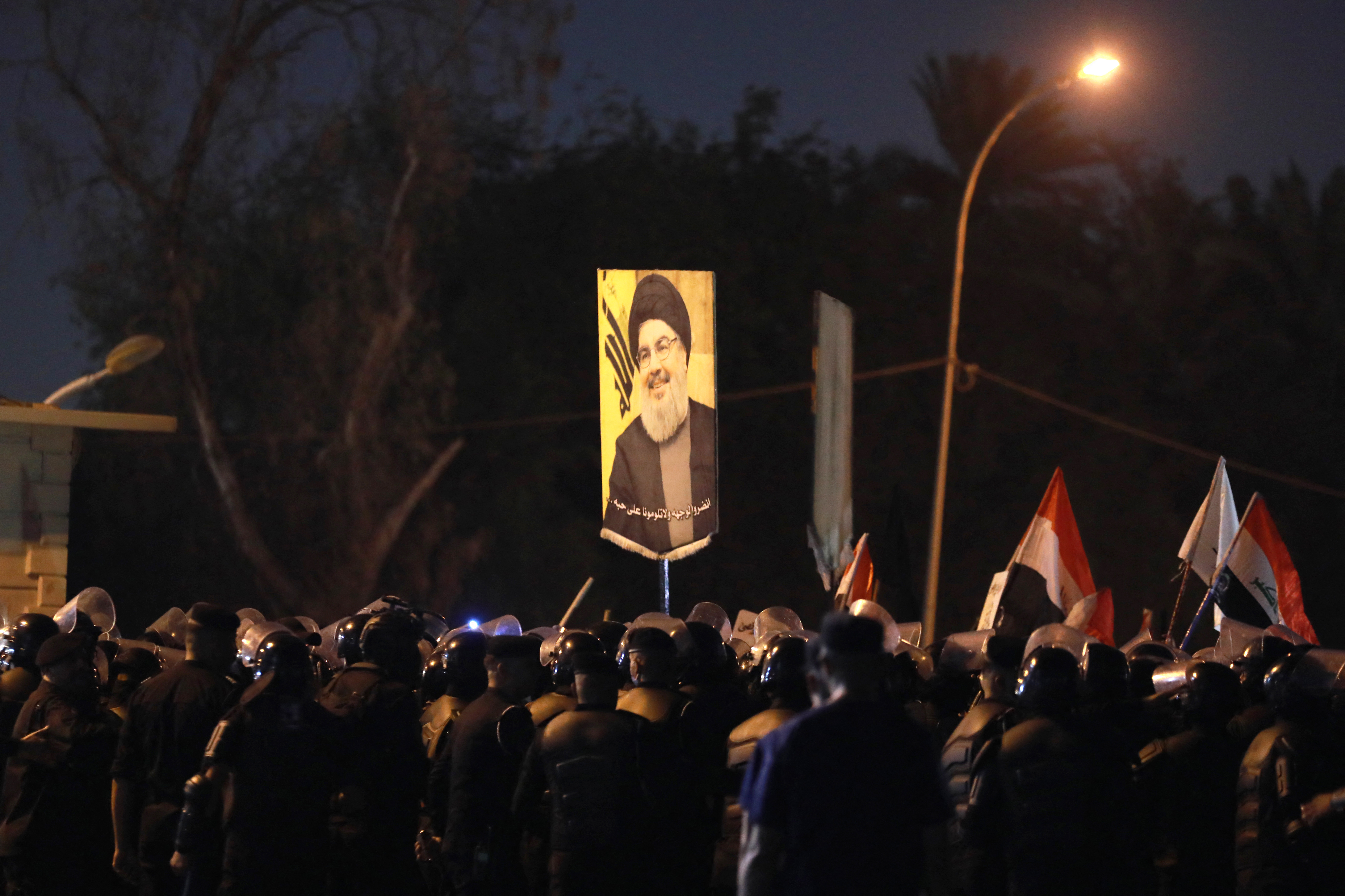 An Iraqi demonstrator holds aloft a picture of Hassan Nasrallah, late leader of the Lebanese group Hezbollah, during a protest vigil near the suspension bridge leading to Baghdad's green zone on September 28, 2024. Photo / AFP