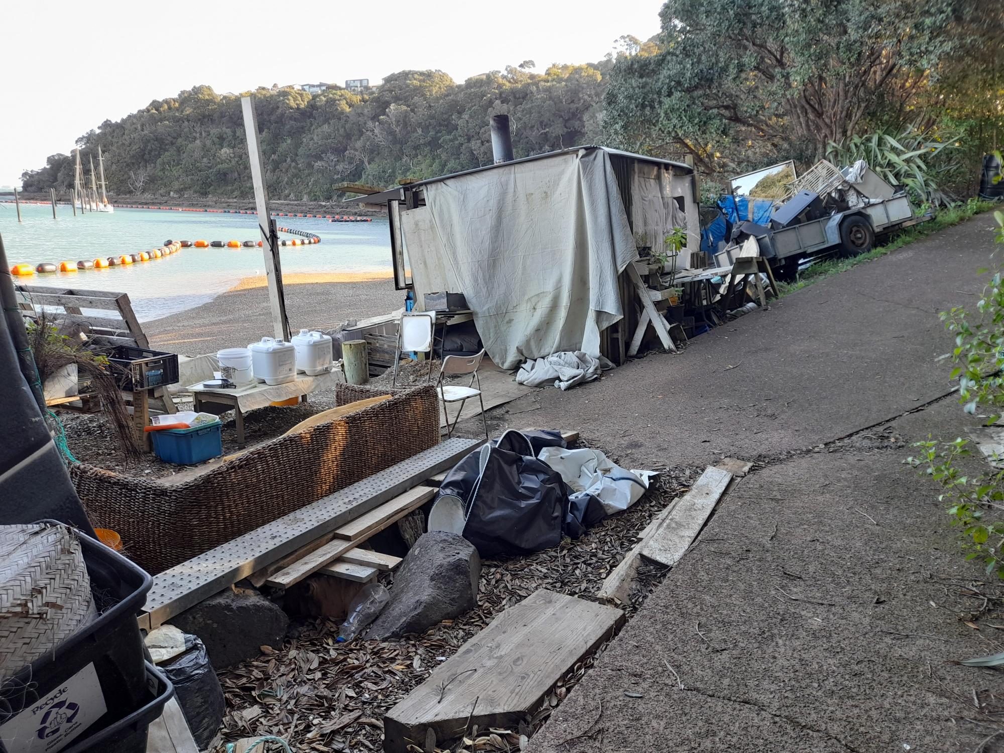 Water bottles, timber, housing structures, a trailer, seats and metal at the camp on Waiheke Island.