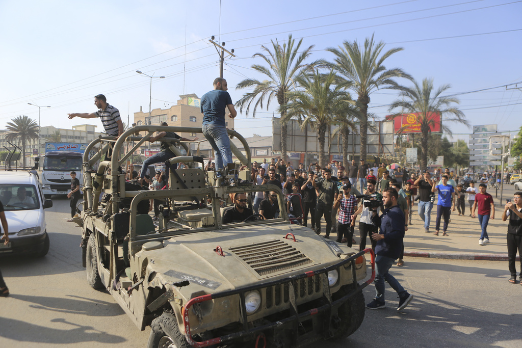 Palestinians ride on an Israeli military vehicle taken by an army base overrun by Hamas militants near the Gaza Strip fence, in Gaza City. Photo / AP