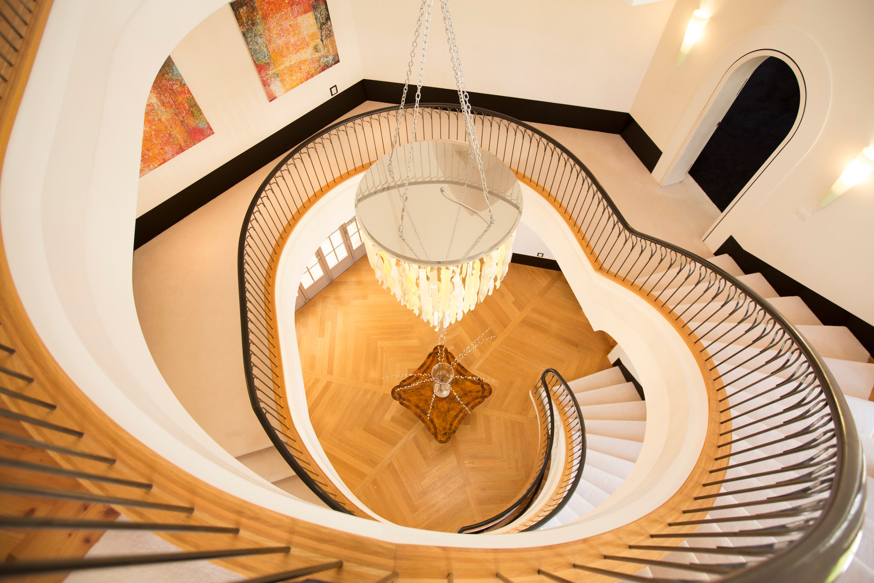 The dramatic winding stairwell at the mansion features balustrades from France and chandeliers from Italy. Photo / Barfoot and Thompson