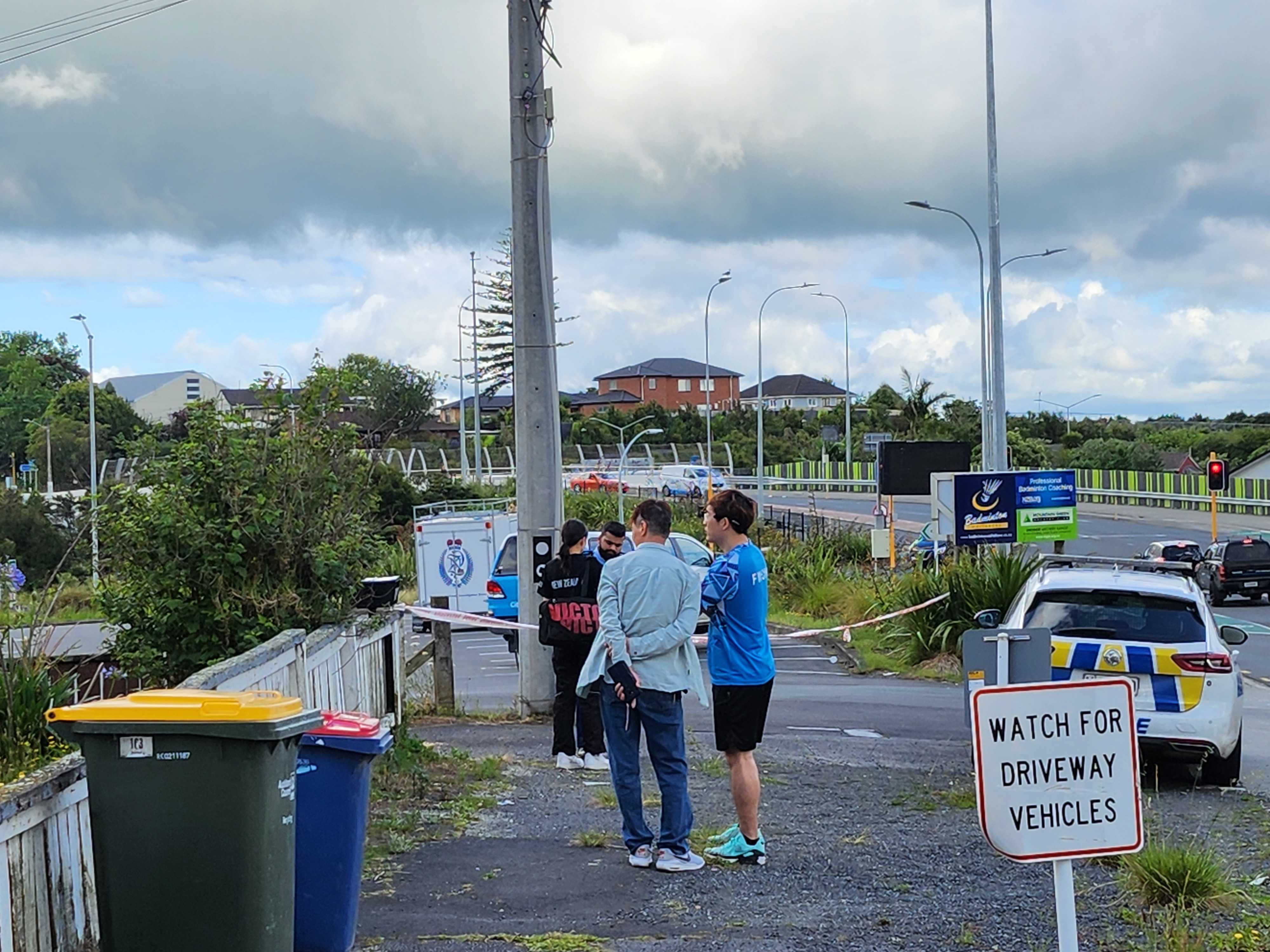 An officer seen speaking to members of Waitakere Badminton Club on Royal Rd, Massey. Photo / Akula Sharma