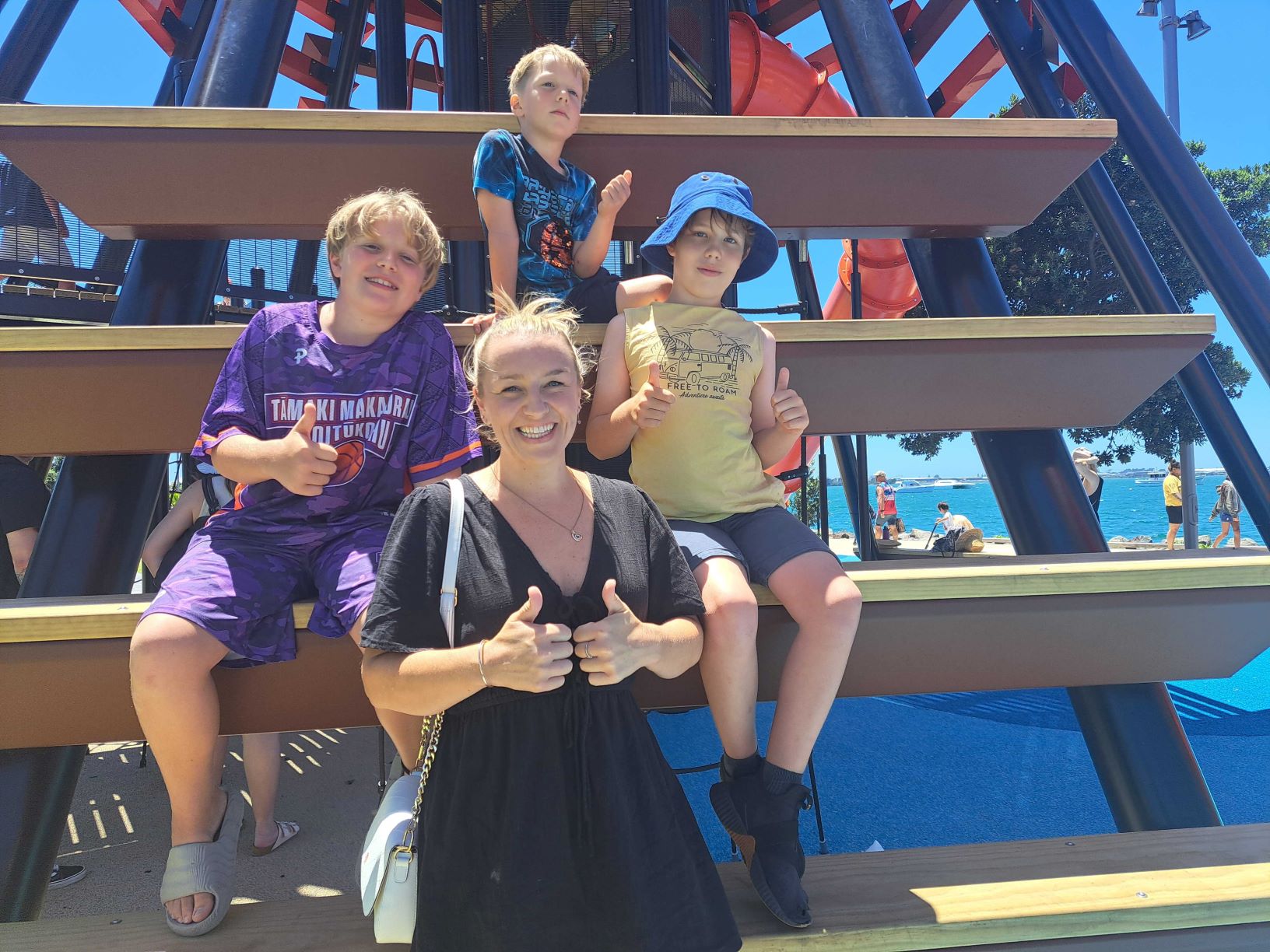 Ōmokoroa mother Sharon Hoseason flanked by sons Oli, 11, ( left) and Donny, 10,  (on her right) and Maddox, 6, (seated behind her) giving the new Tauranga waterfront playground their sign of approval during their December 20 visit.  Photo / Sandra Conchie