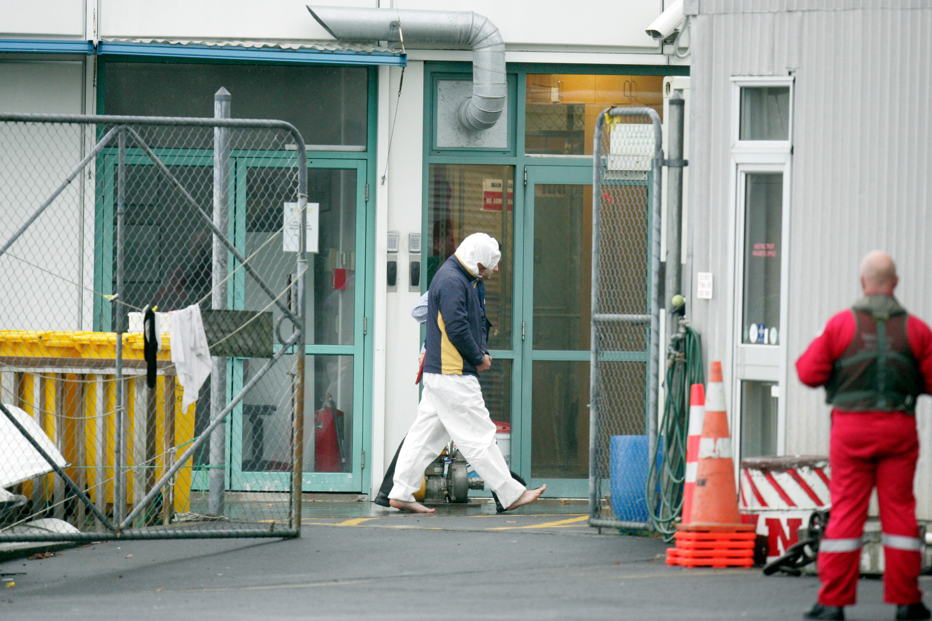 Police leading Nathan Boulter in handcuffs from the police launch at Mechanics Bay after his arrest on Great Barrier Island in 2011. Photo / Michael Craig