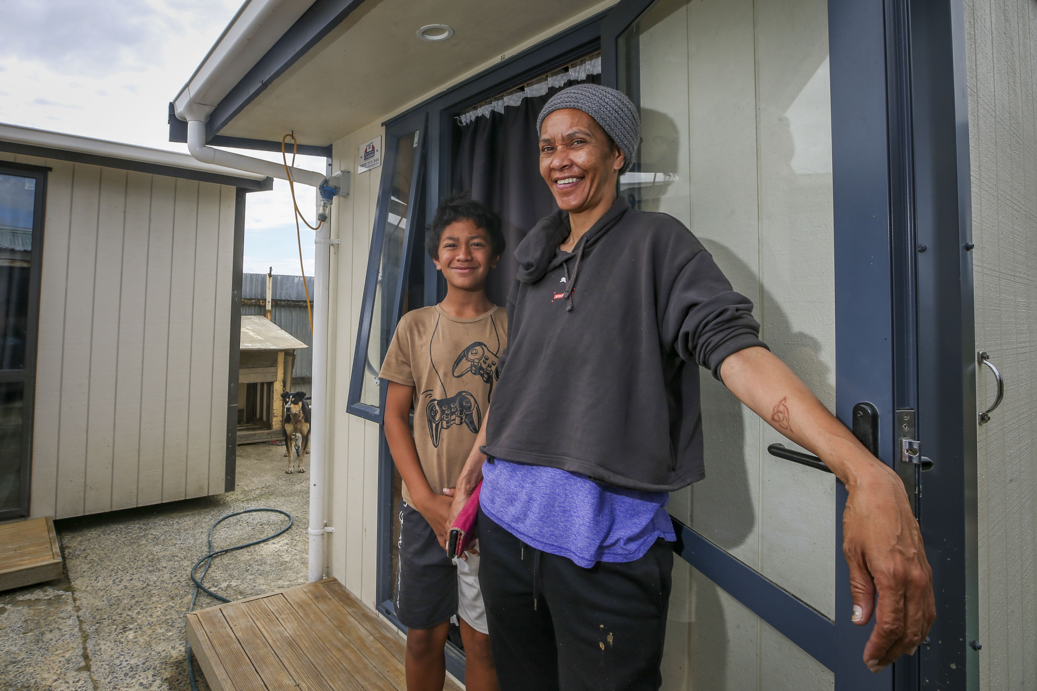 Terina Henare and grandson Kora Barber outside the temporary sheds used as accommodation on their cyclone-hit Wairoa property. Photo / Paul Taylor