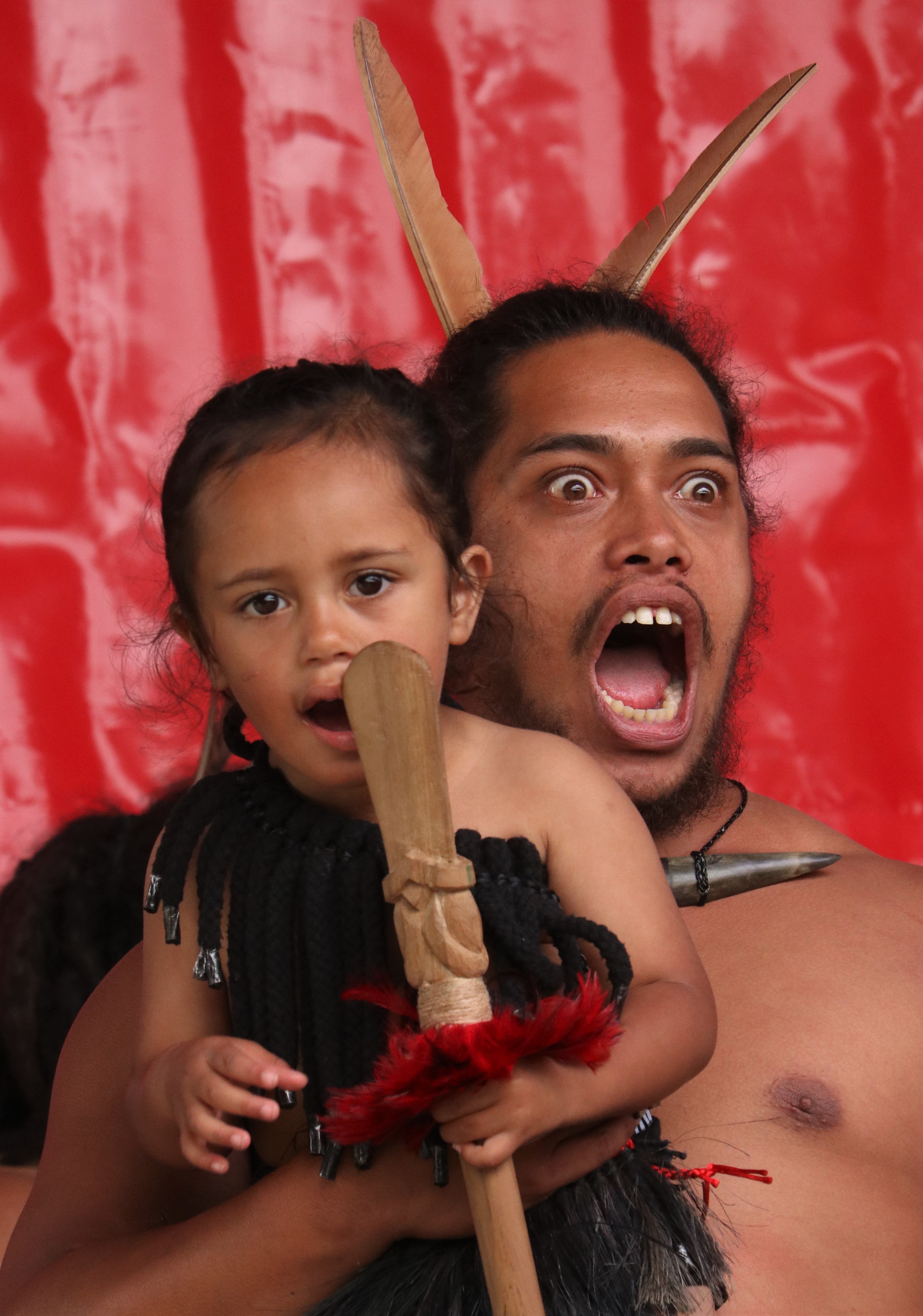 Hamiora Tautu holds his two-year-old son Tumata-Rauiri Eruera Waitai-Henare Tautu during a performance by Muriwhenua kapa haka group. Photo / Peter de Graaf